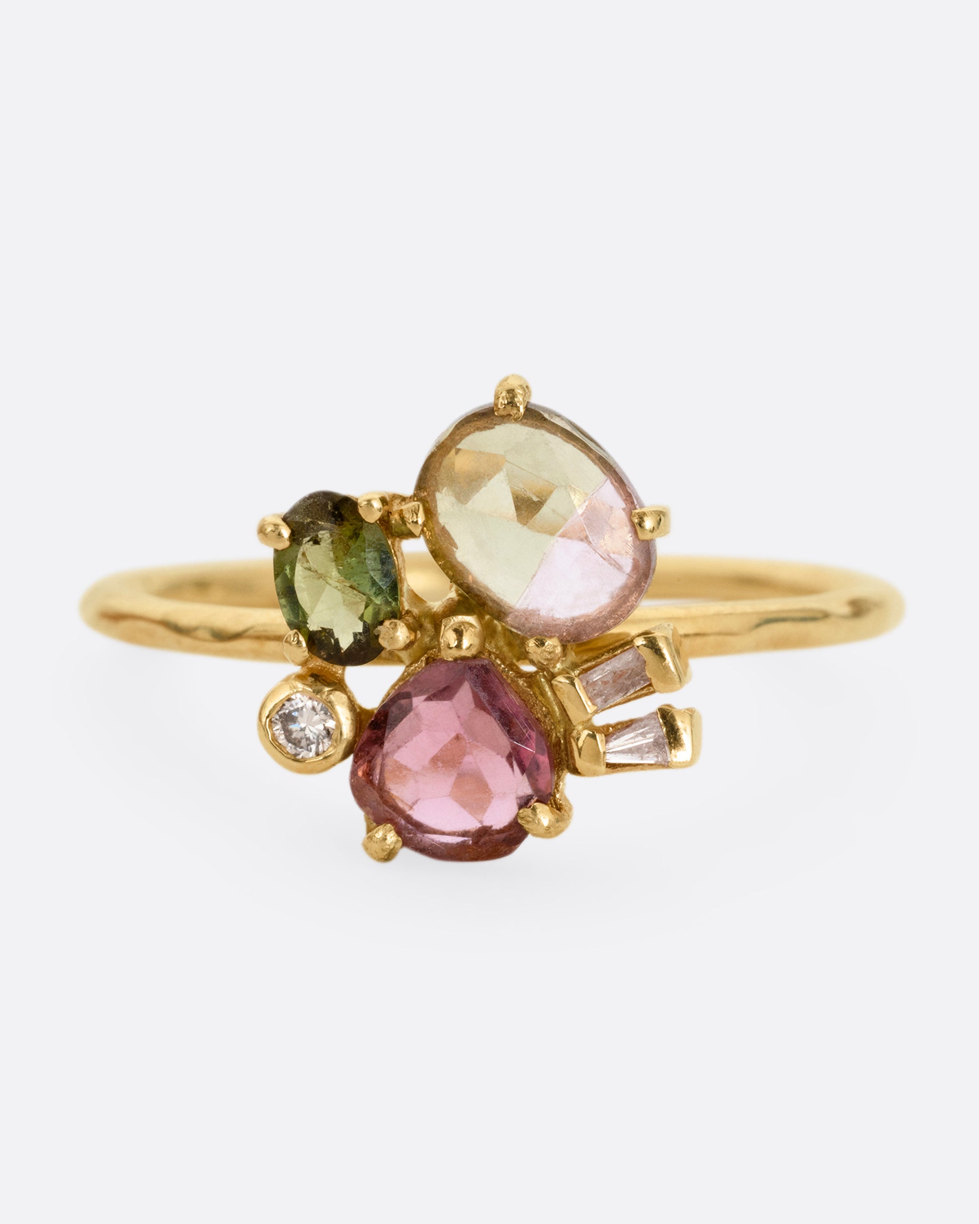A yellow gold ring with green and pink tourmalines and three diamonds. Shown from the front.
