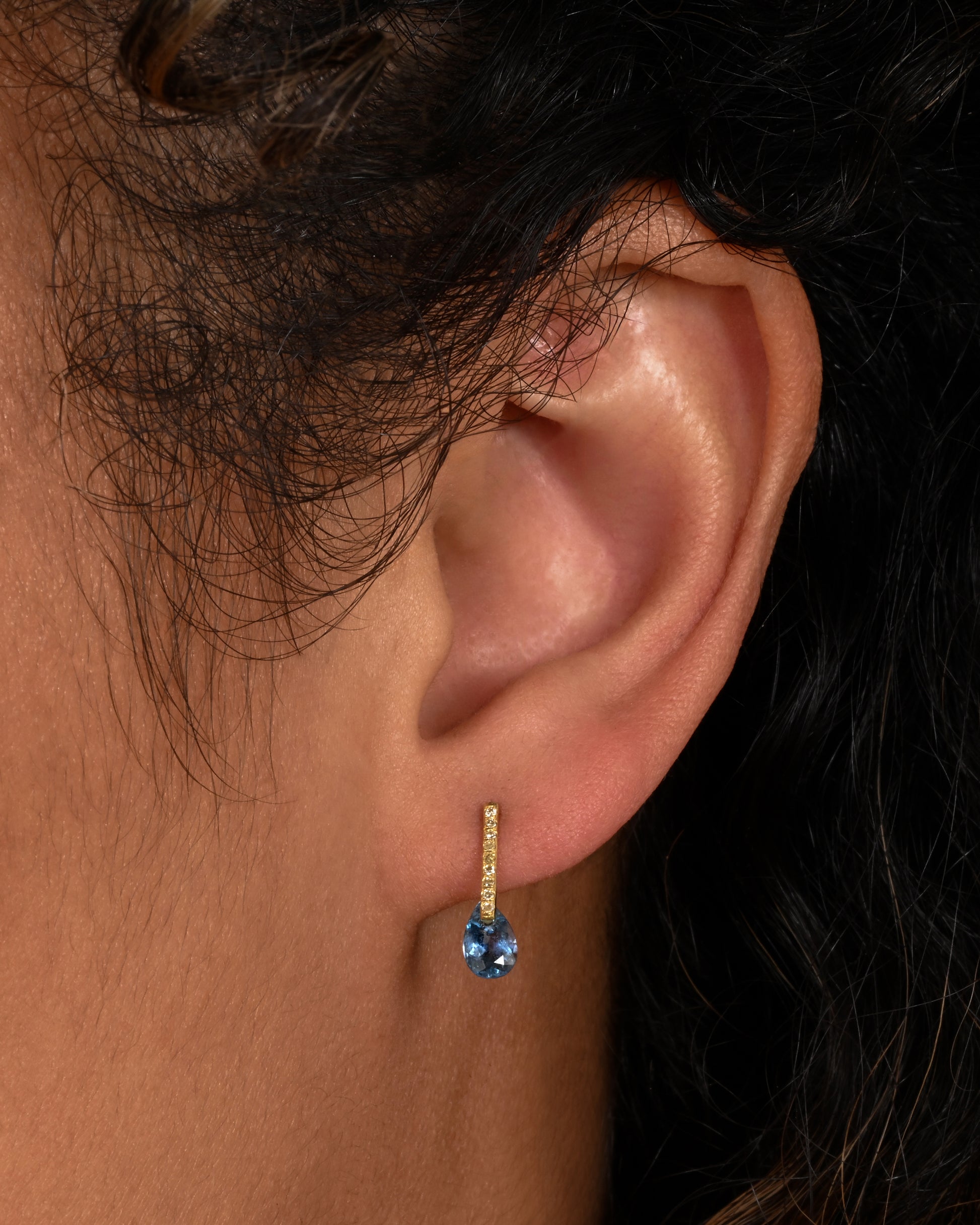 yellow gold earrings with aquamarines and diamonds  shown on an ear