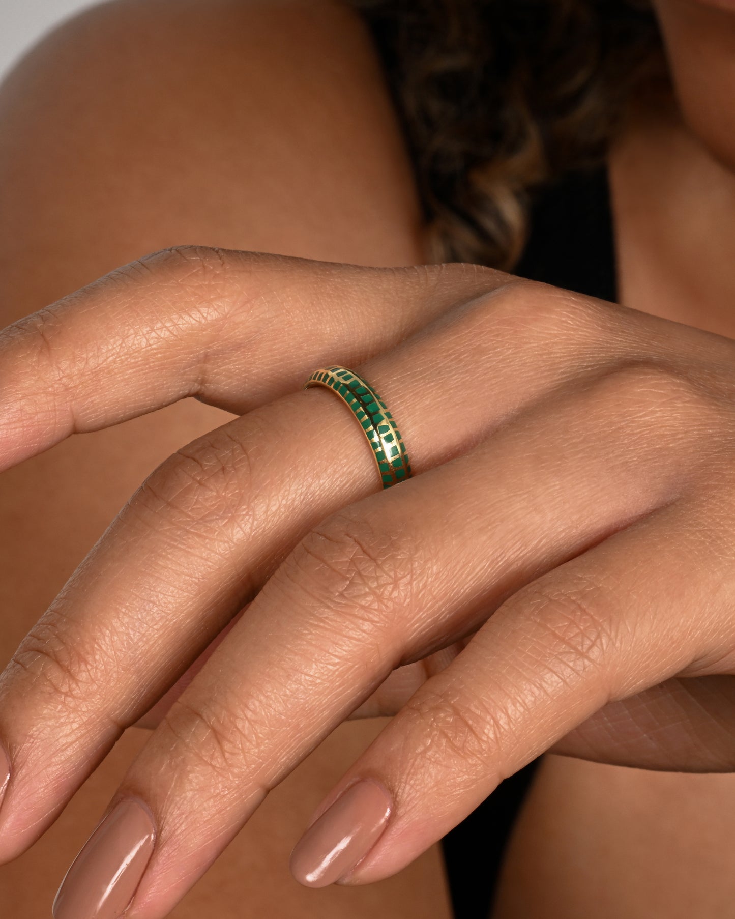 A yellow gold band with an irregular checkered pattern all the way around. Shown worn.