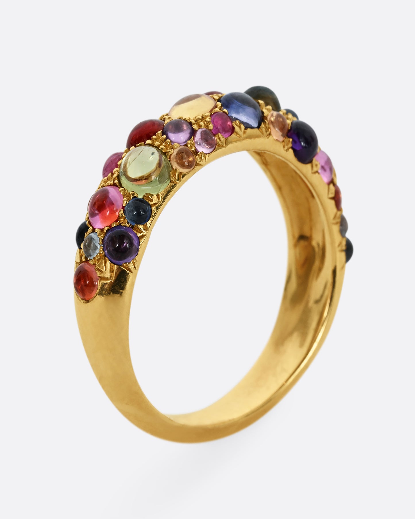 Multicolor sapphire cabochons set in an 18k yellow gold band. Shown from the side, standing up.