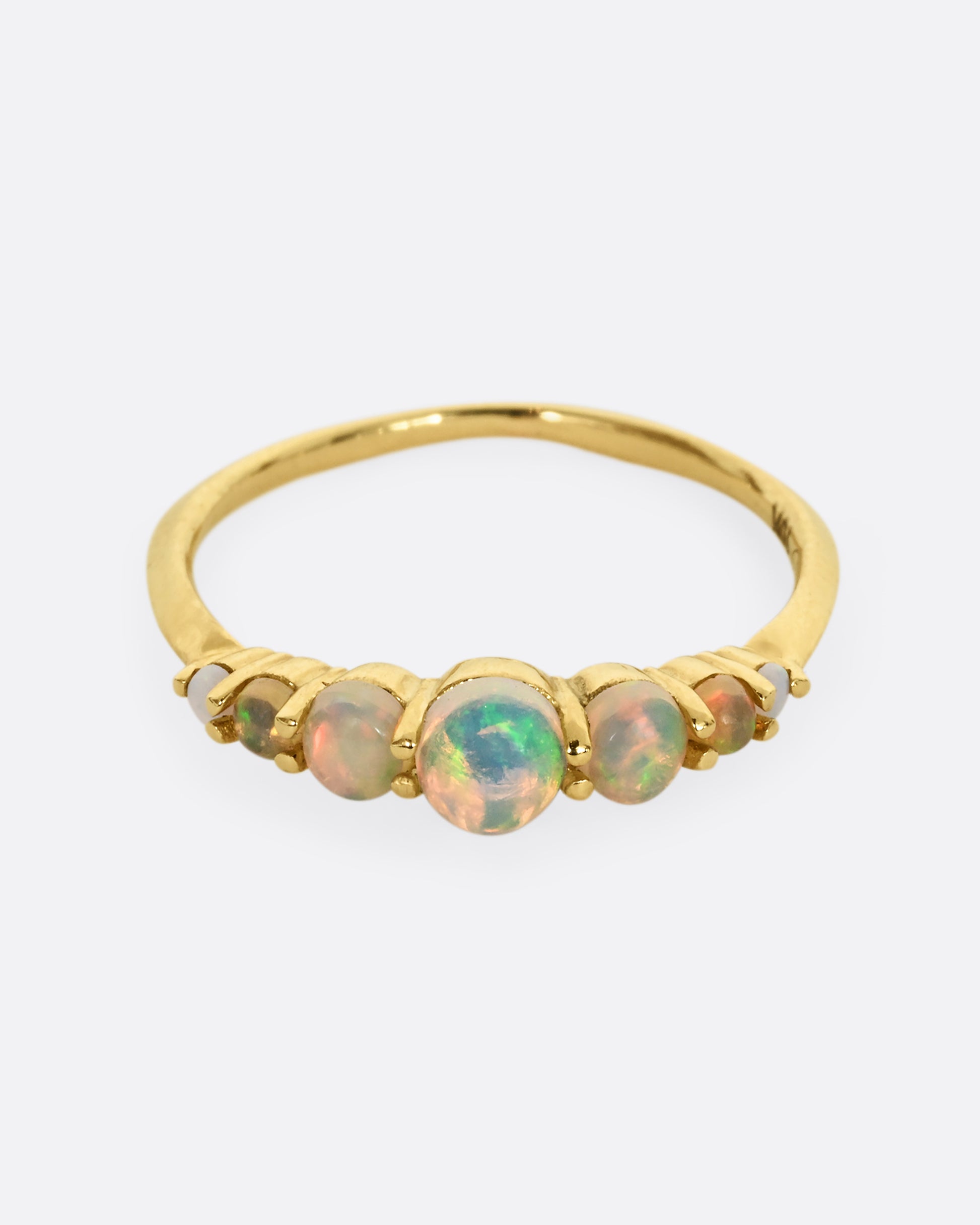 Seven graduated opals set in 18k yellow gold band. Shown from the front.