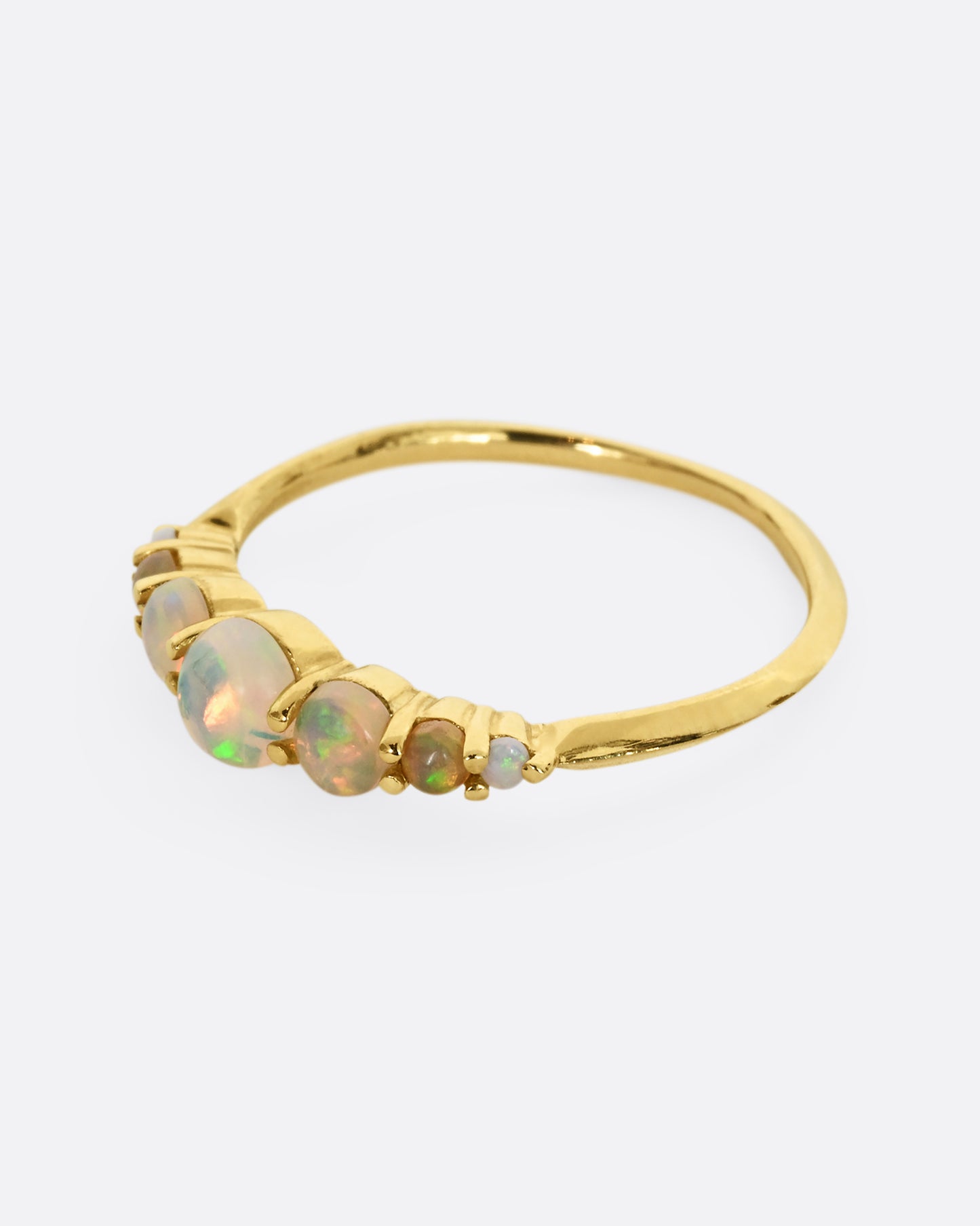 Seven graduated opals set in 18k yellow gold band. Shown from the side.