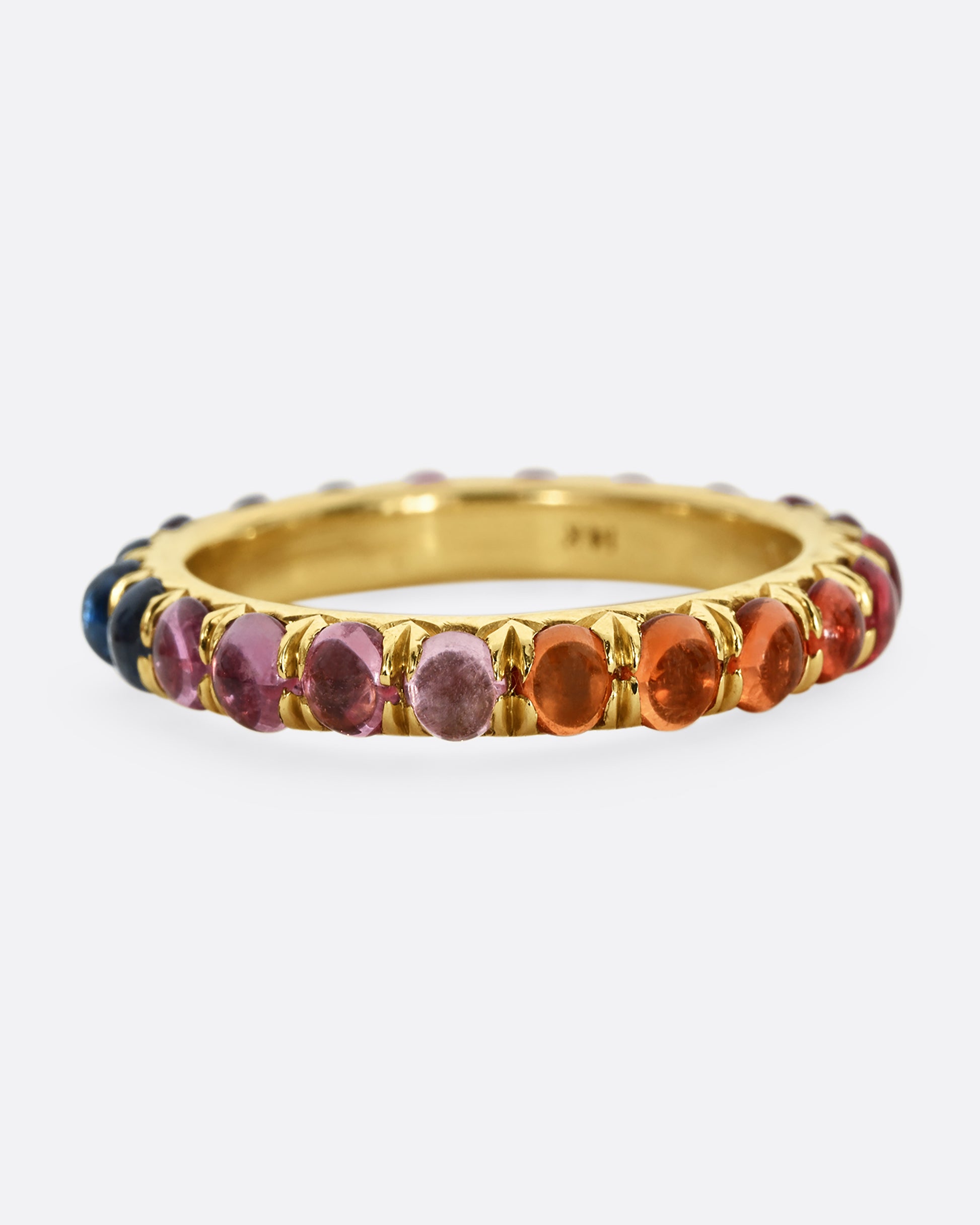 A yellow gold eternity band with rainbow sapphire cabochons.