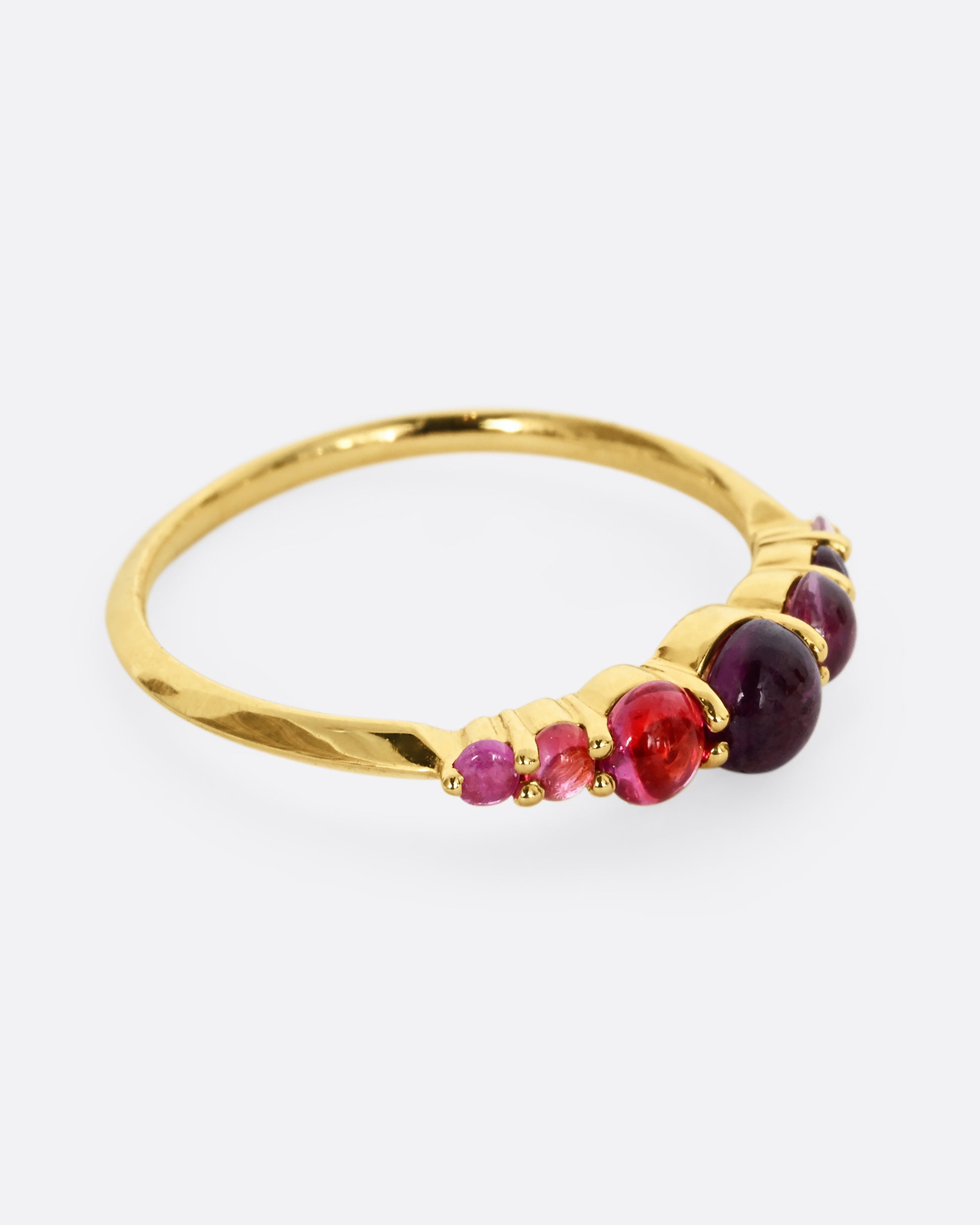 Pink and purple graduated sapphires set in 18k yellow gold. View from the side.