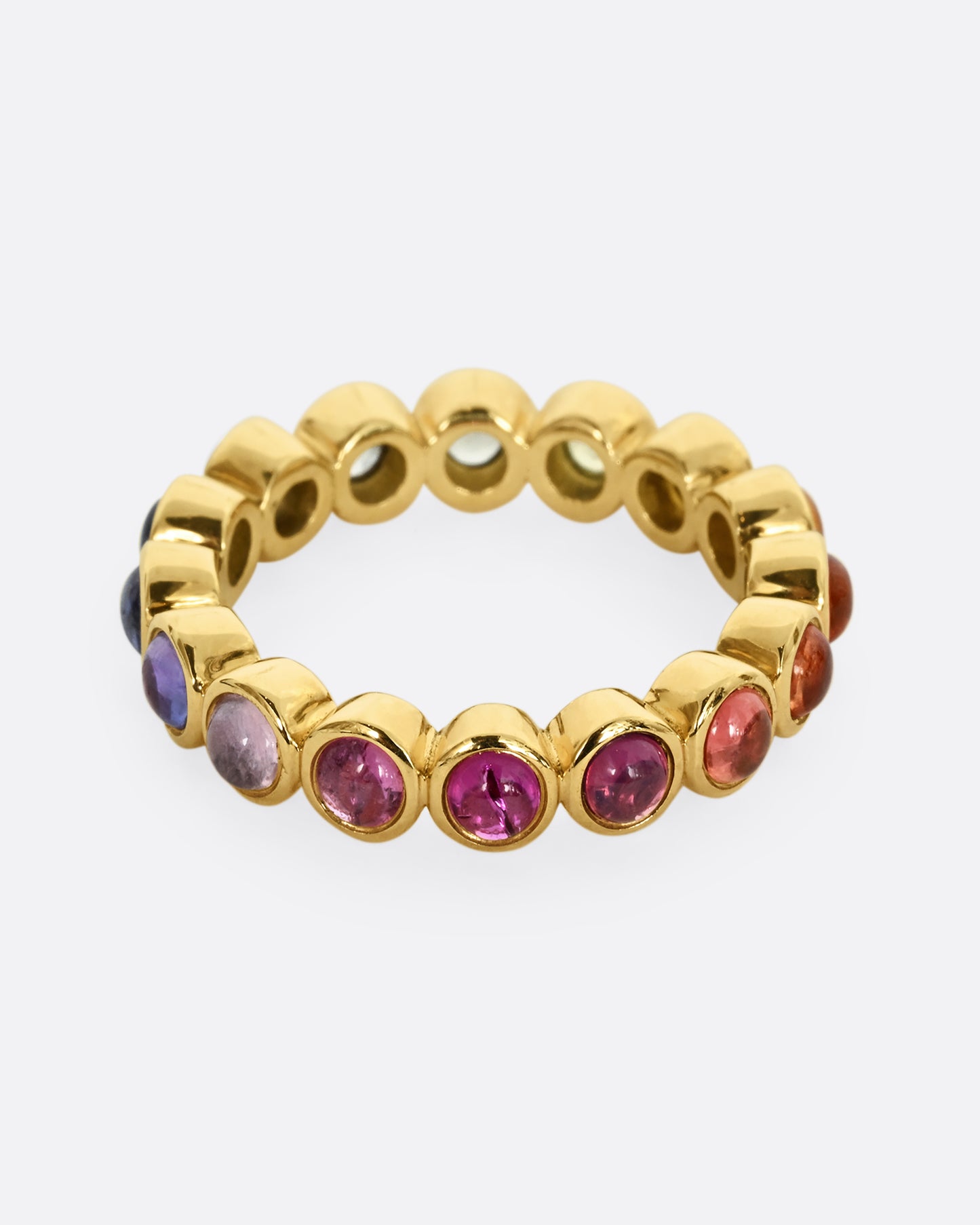 A yellow gold half eternity band with multicolor bezel set sapphire cabochons. 