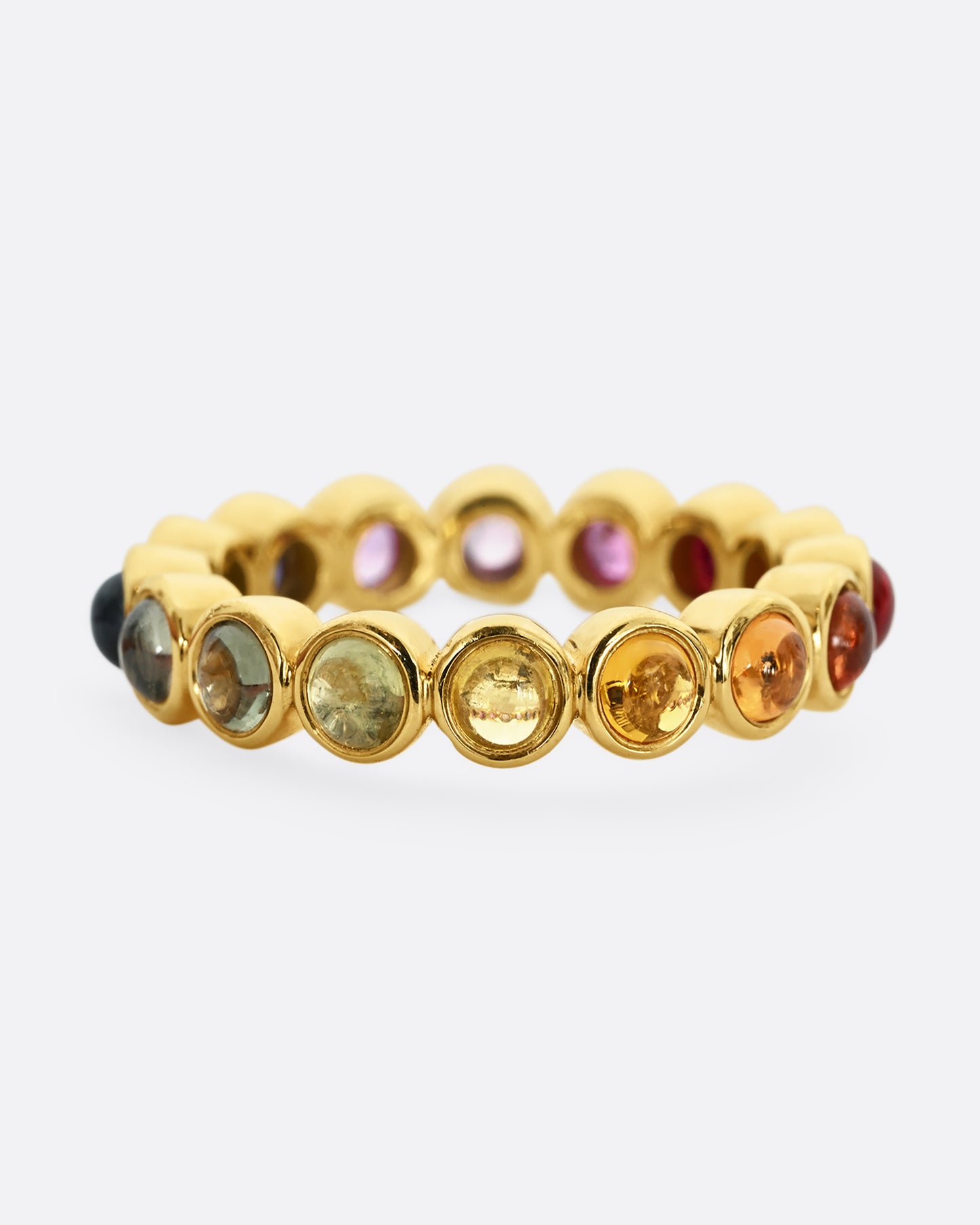 A yellow gold half eternity band with multicolor bezel set sapphire cabochons. 