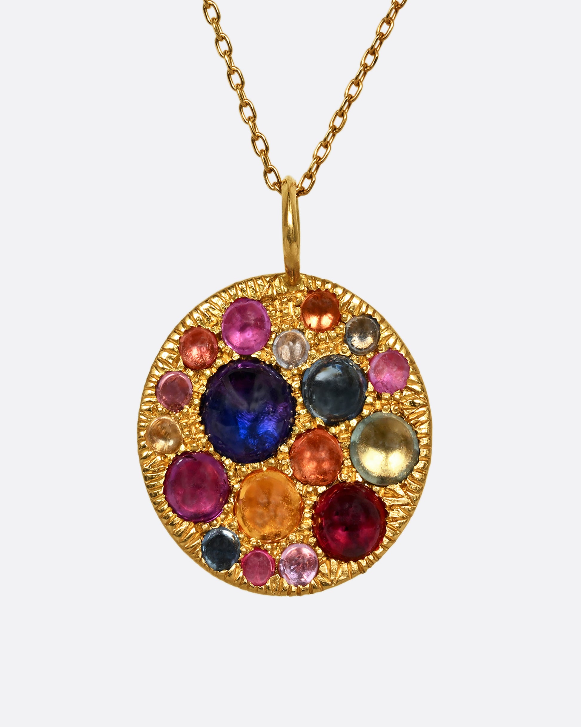 A yellow gold pendant with multicolor cabochon sapphires. View from the front.