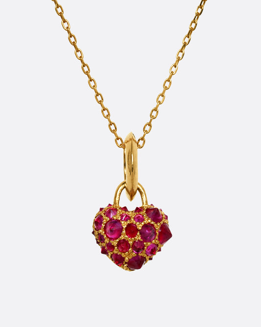 A yellow gold heart shaped charm with inverted rubies throughout. View from the front.