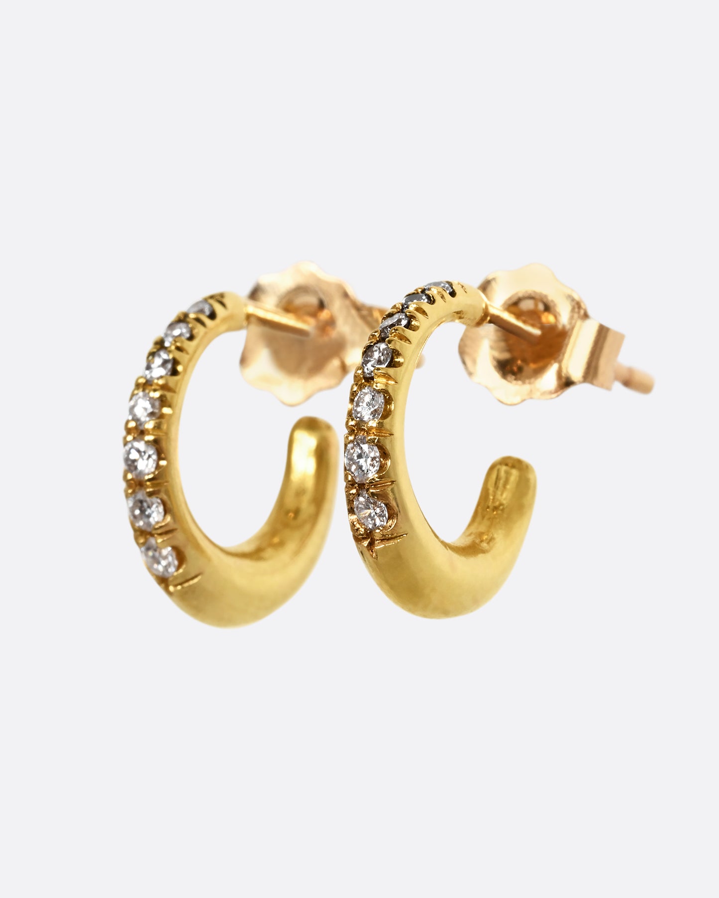 A yellow gold earring with graduated diamonds. Shown from the side as a pair.