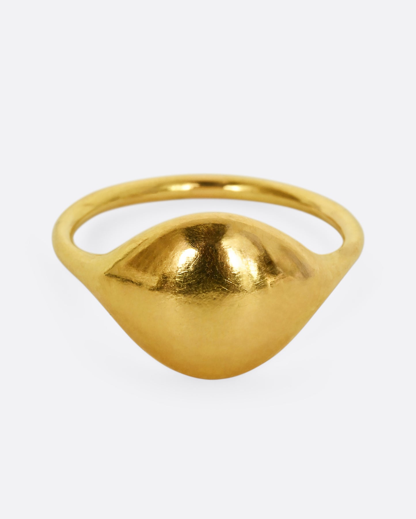 A yellow gold rounded signet ring. Shown from the front.