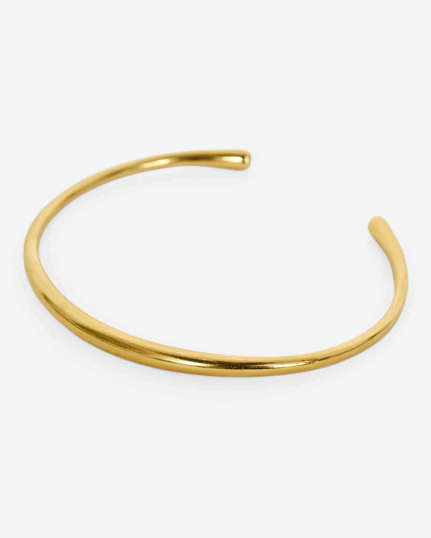 A yellow gold cuff bracelet. Shown from the side.