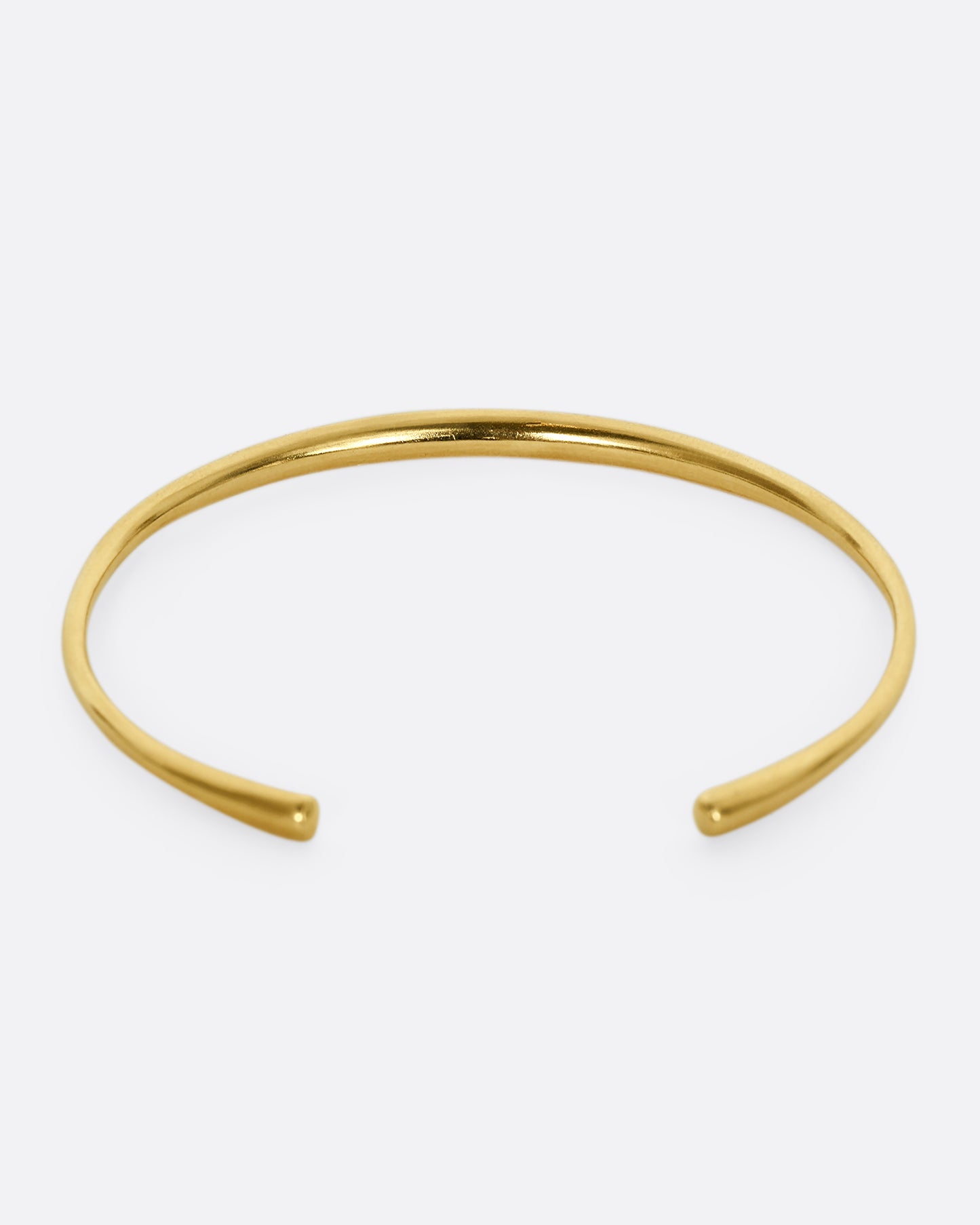 A yellow gold cuff bracelet. Shown from the back.