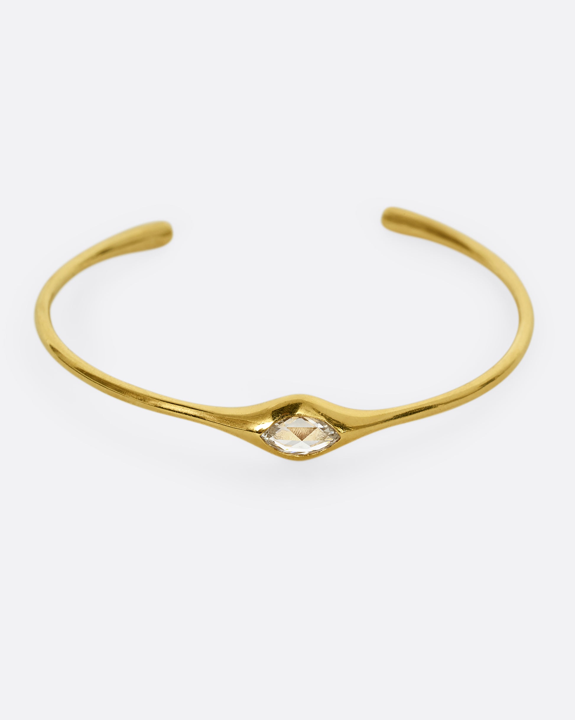 A yellow gold cuff with a marquis diamond. Shown from the front.