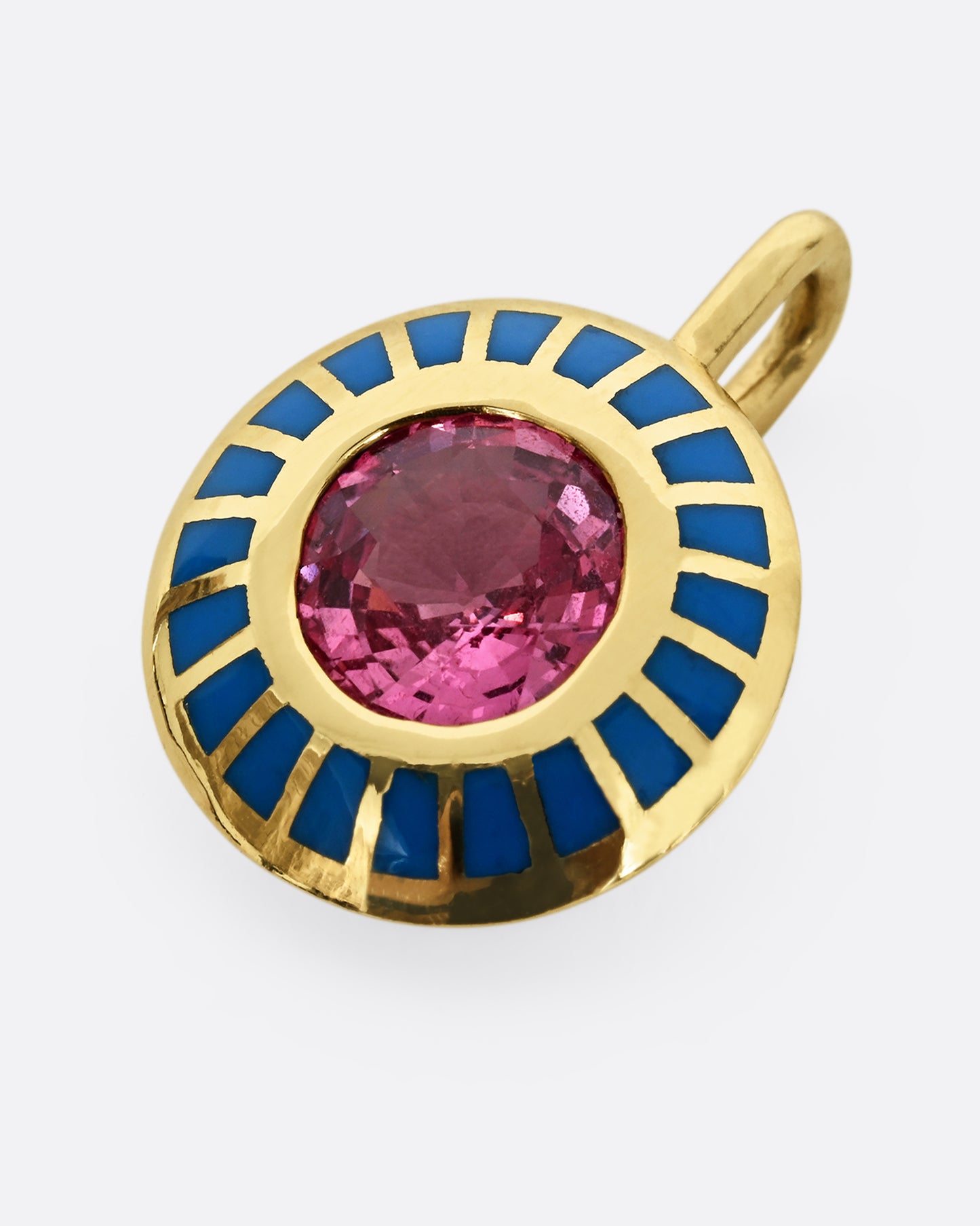 A yellow gold pendant with light blue enamel surrounding a pink sapphire. Shown laying flat.