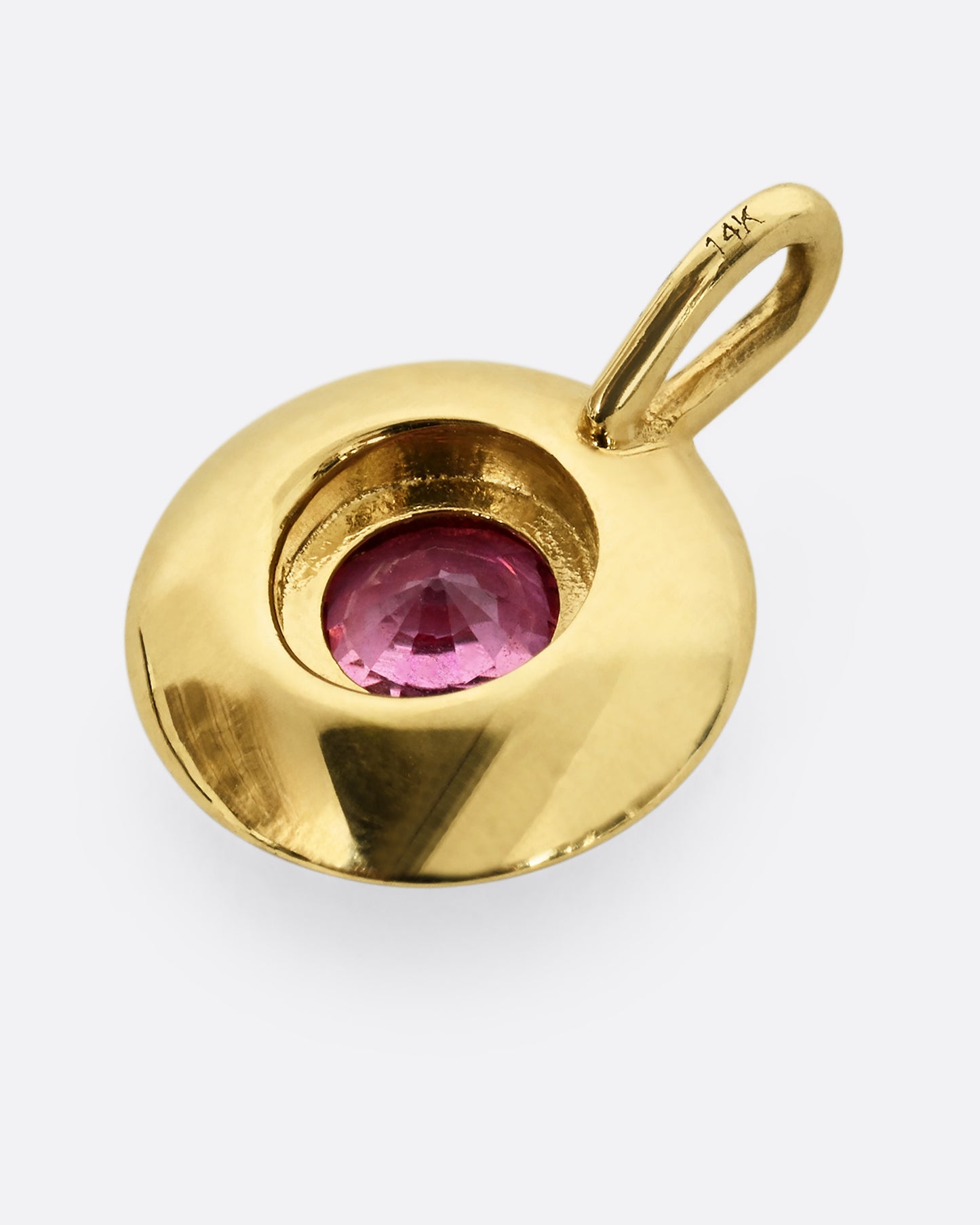 A yellow gold pendant with light blue enamel surrounding a pink sapphire. Shown from the back.