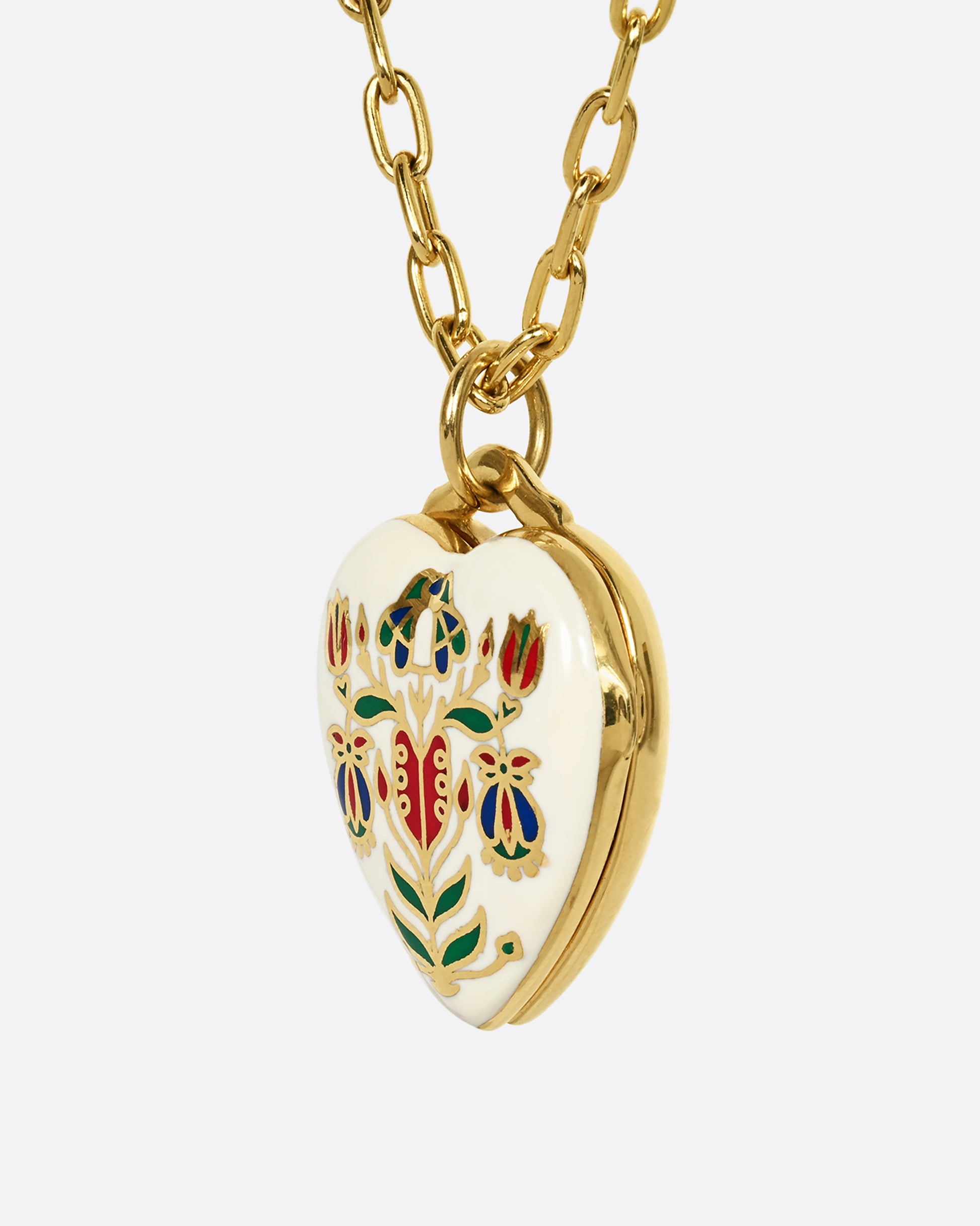 A yellow gold heart shaped locket with a multicolor floral motif on a heavy chain. Shown from the side.