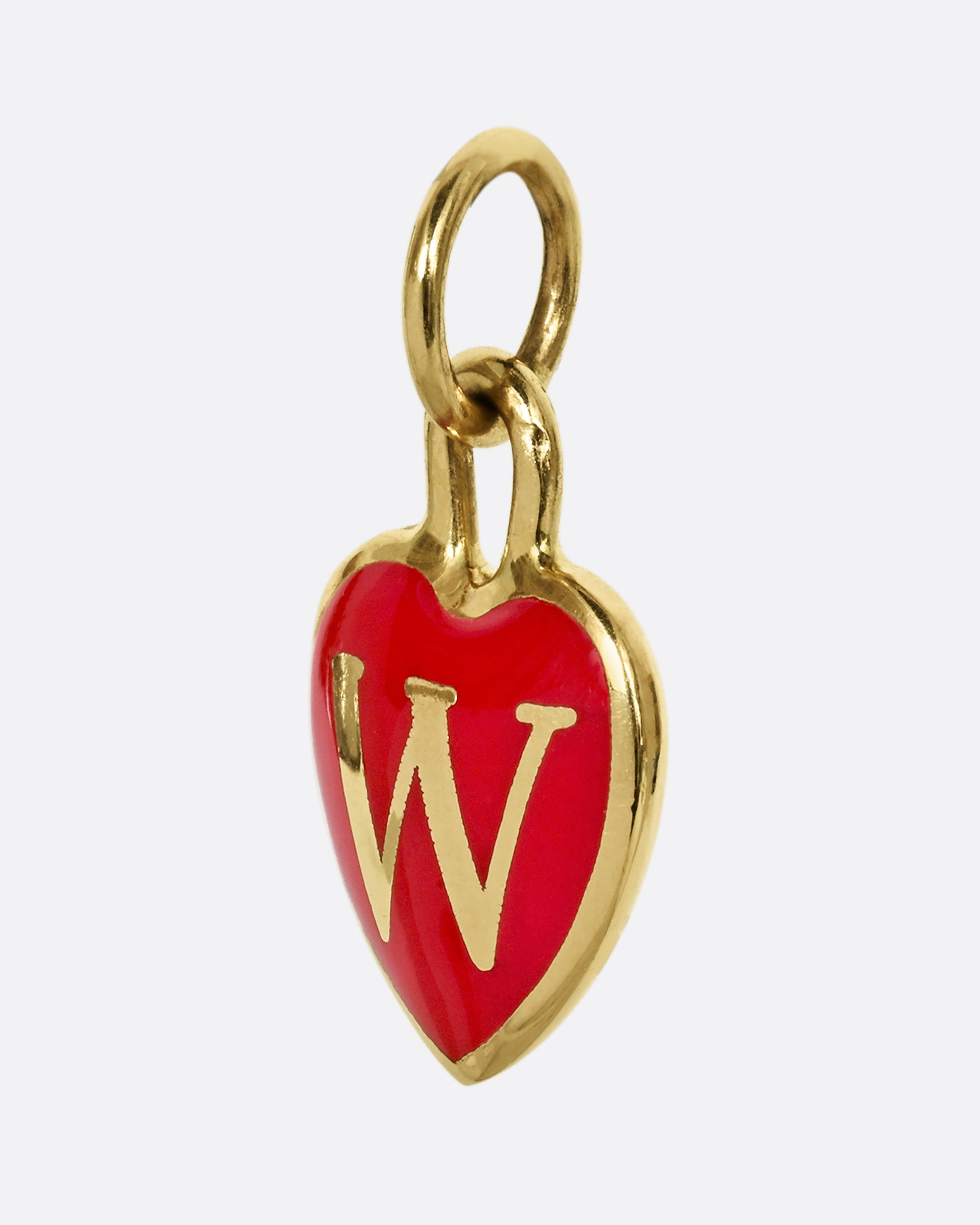 A yellow gold letter "W" heart shaped charm with red enamel. Shown from the side.