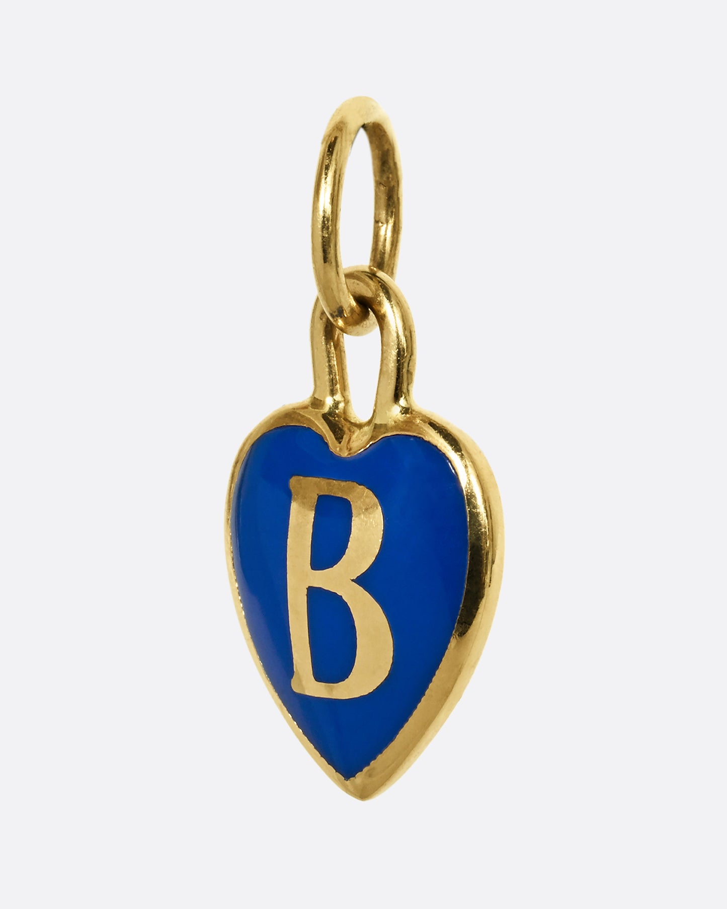 A yellow gold letter "B" heart shaped charm with blue enamel. Shown from the side.