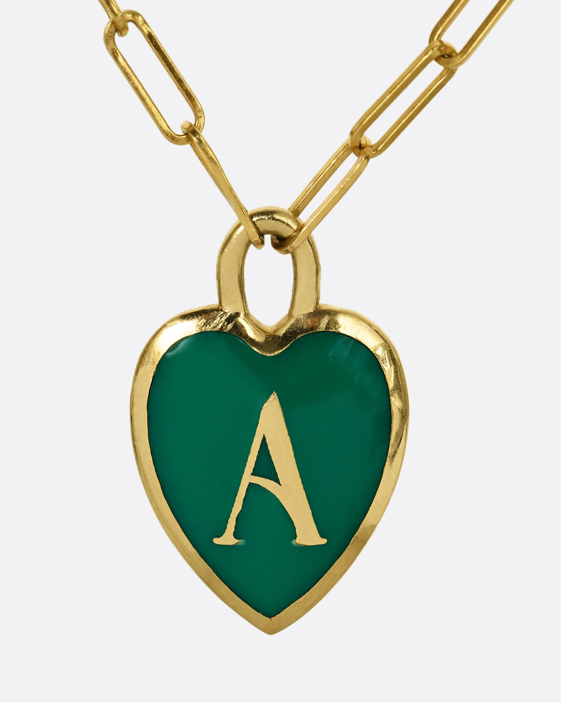 A yellow gold paper clip chain necklace with a heart shaped pendant that has green enamel and the letter "A". Shown from the front.