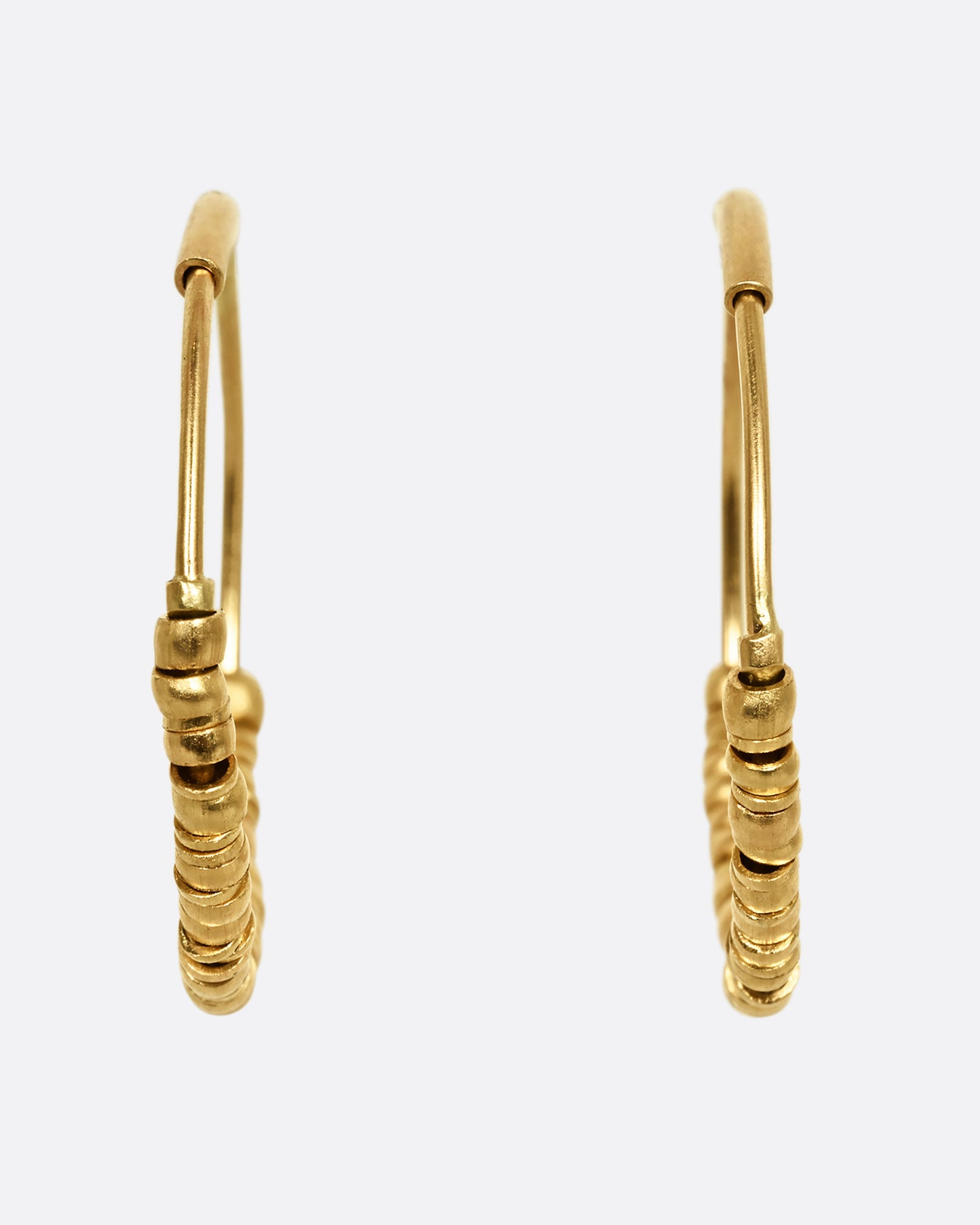 Yellow gold hoop earrings with beads and tube closure. Shown from the front.