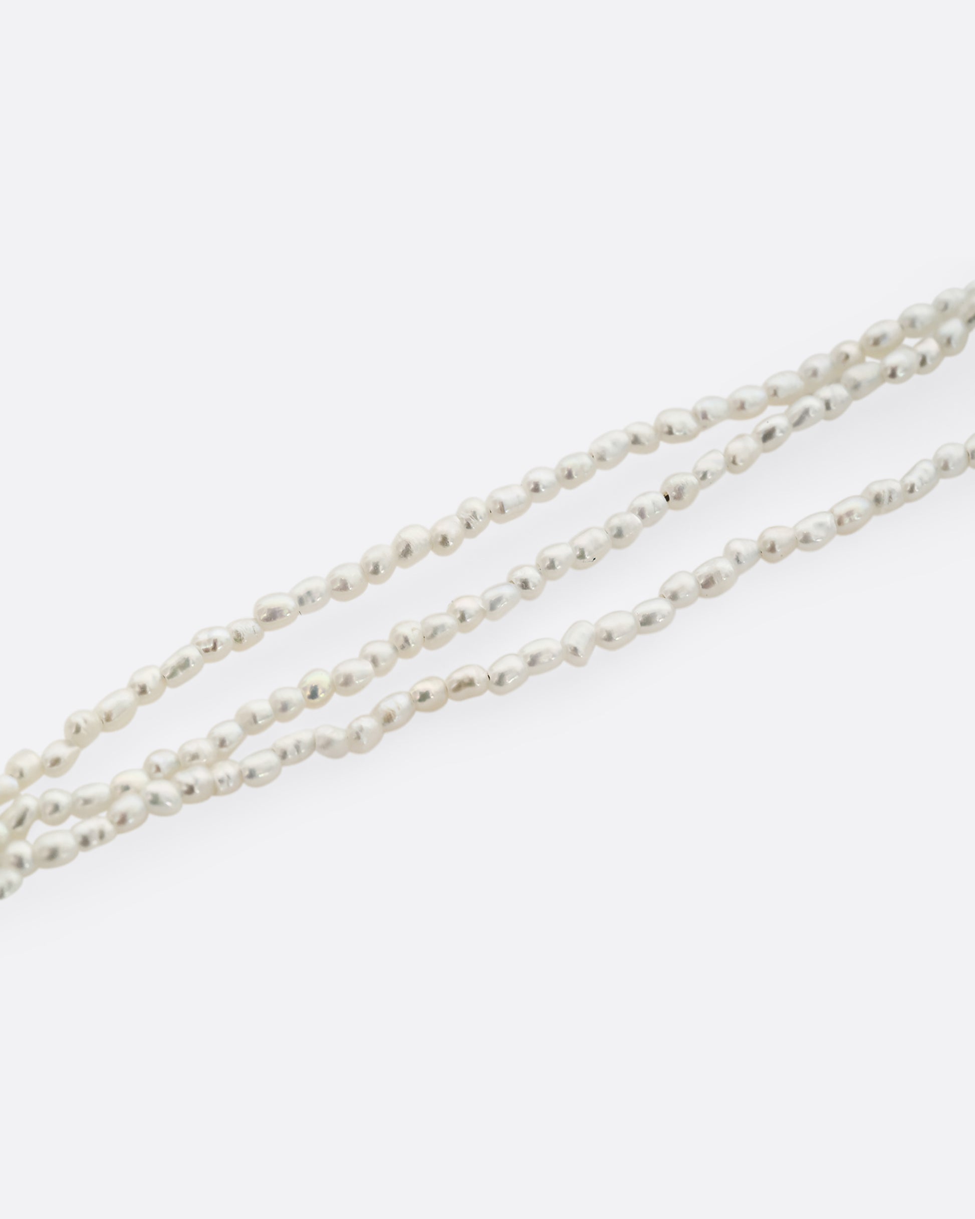 A three strand pearl necklace, shown close up. 