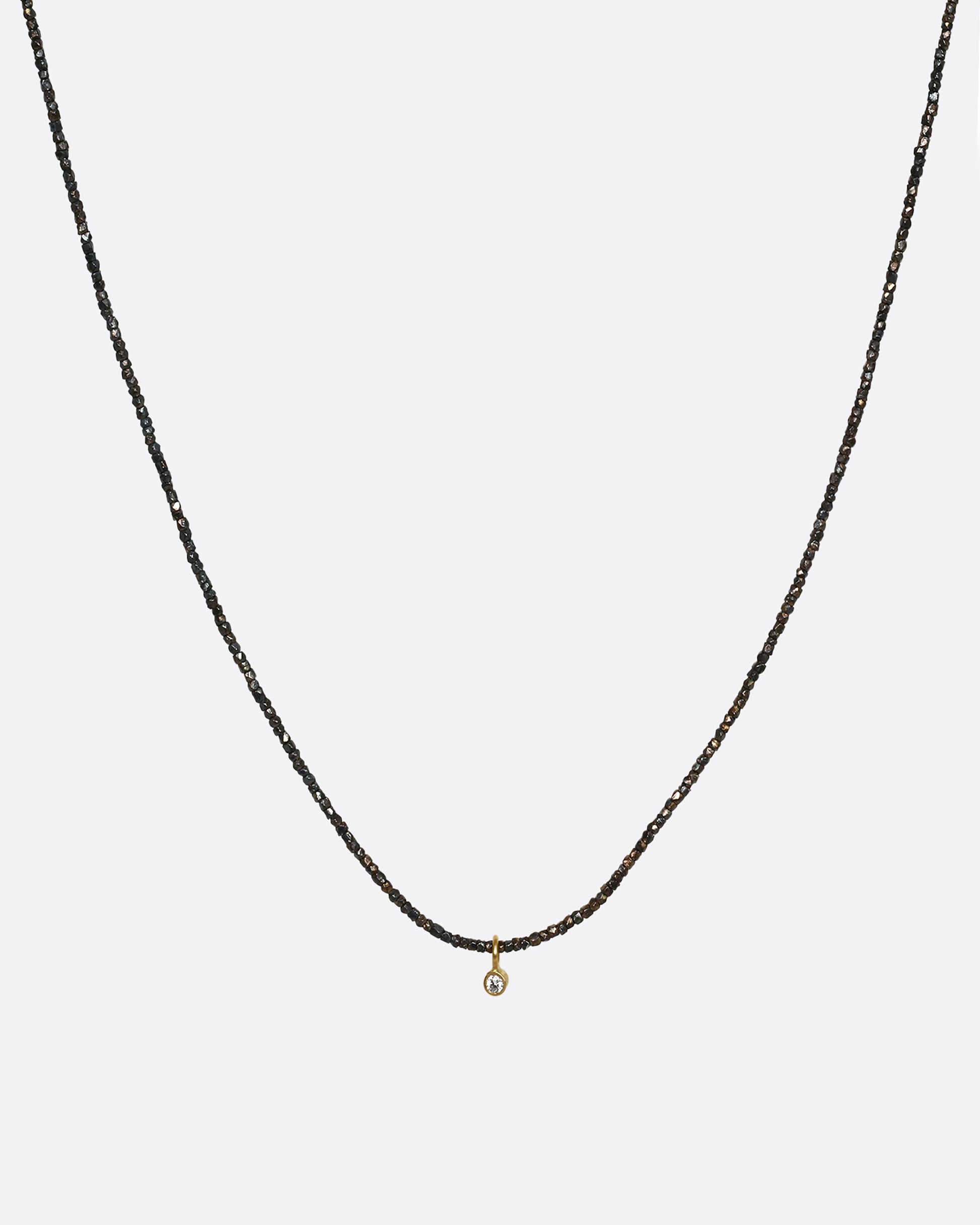 An oxidized silver necklace with a single diamond pendant. Shown from the front.