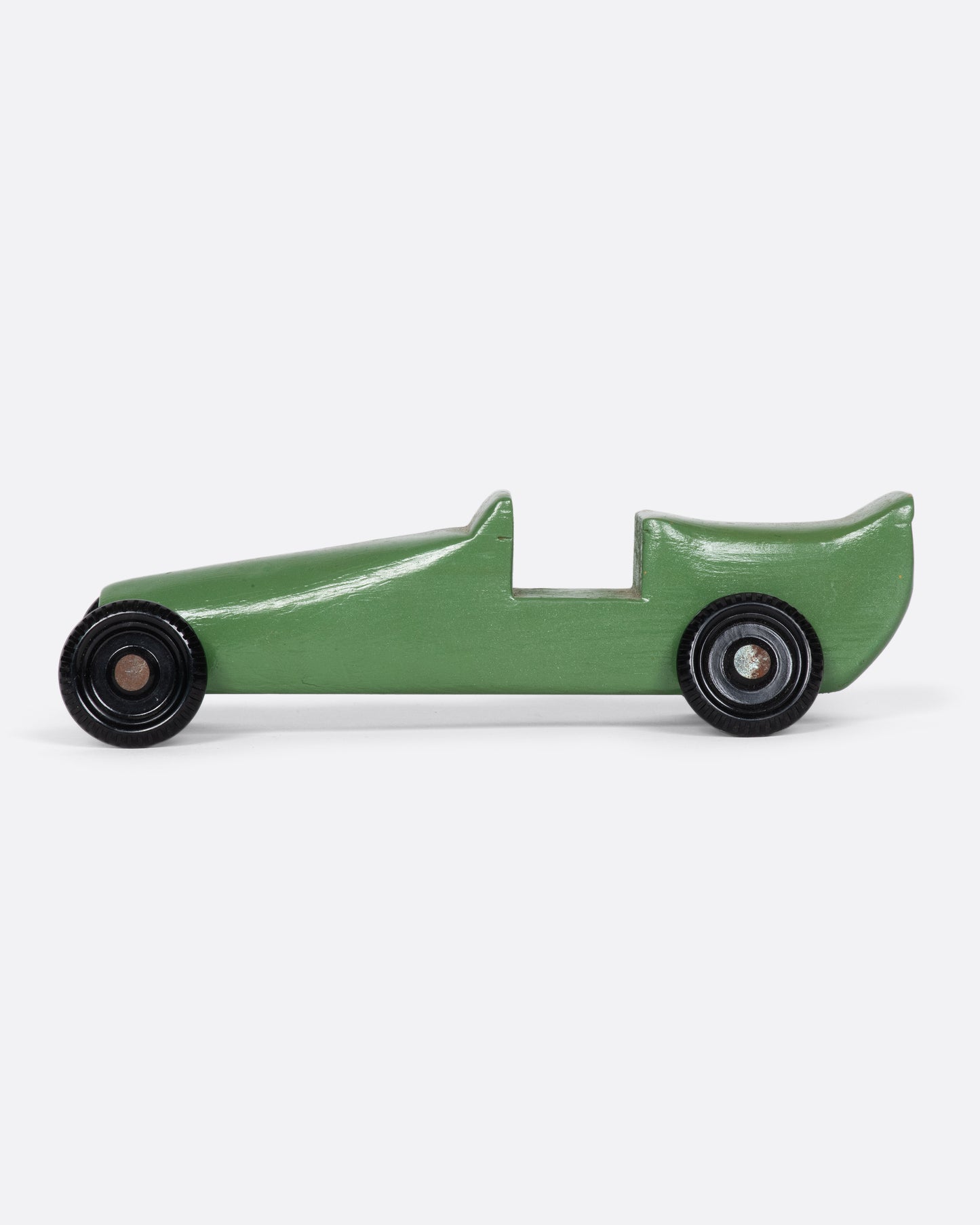 A green wooden toy car with a racing stripe.