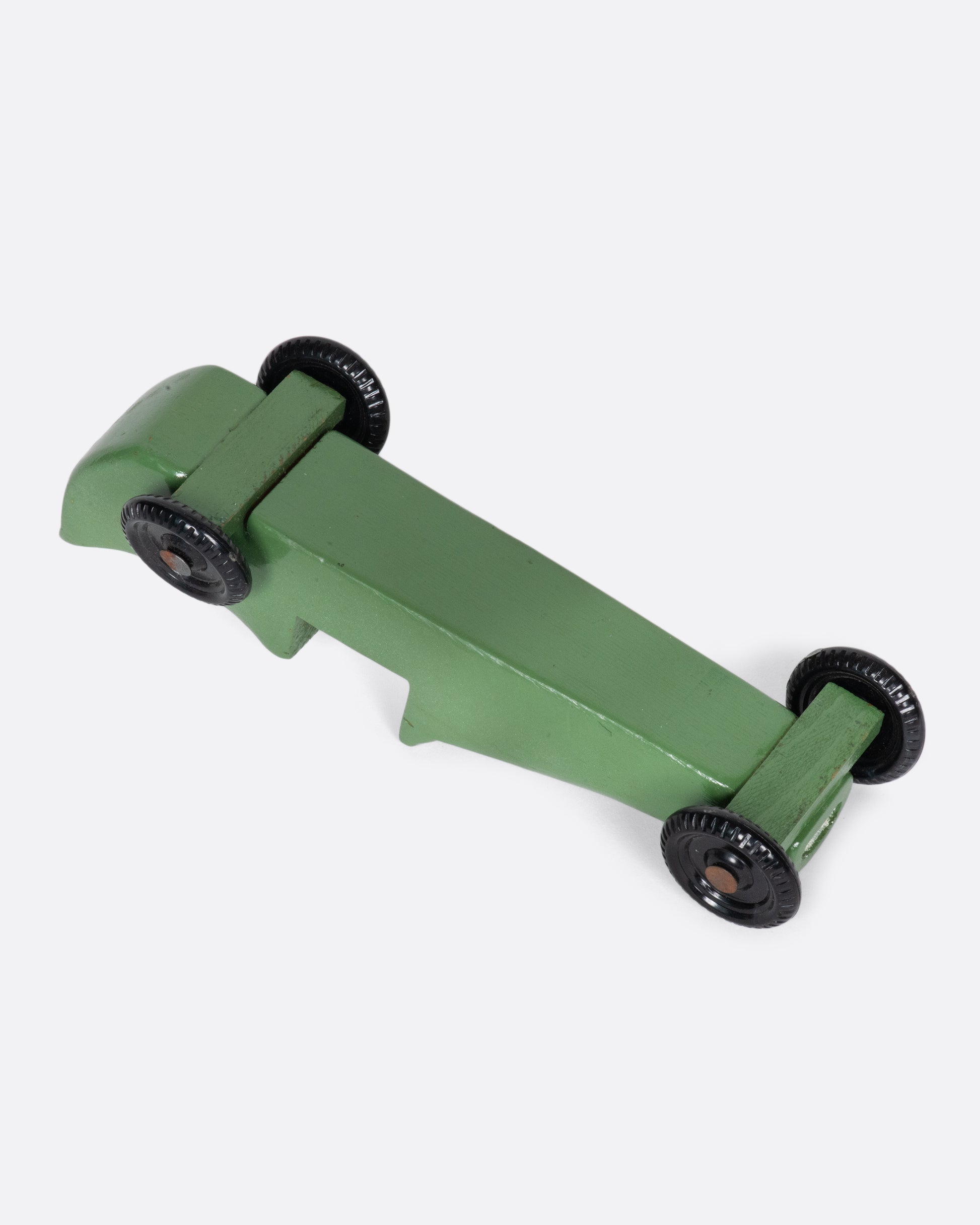 A green wooden toy car with a racing stripe.