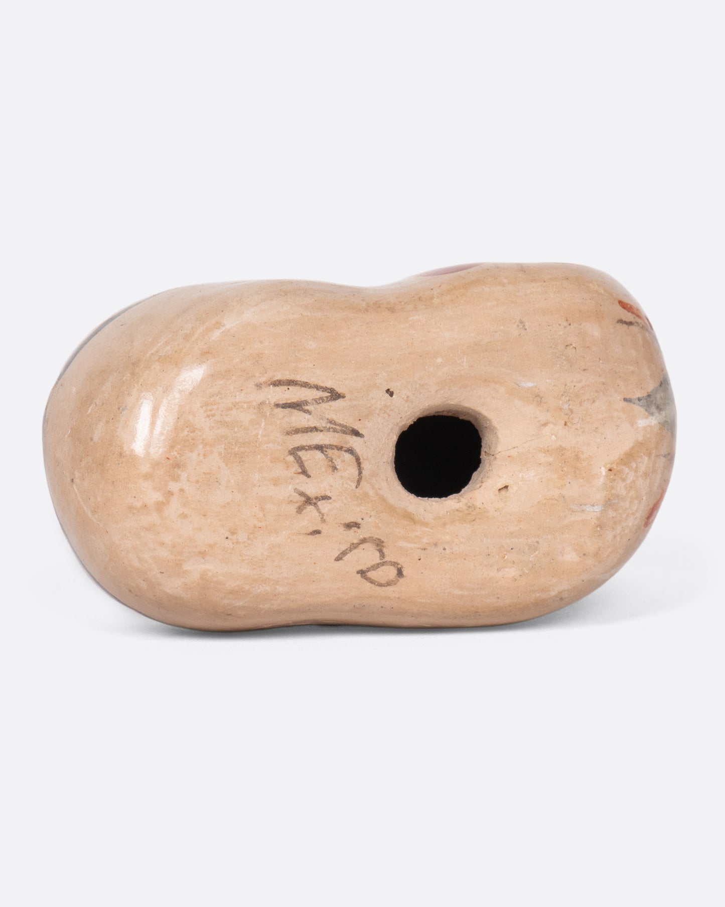 The word "Mexico" painted on the bottom of the cat figurine.