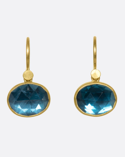 Yellow gold London blue topaz drop earrings, the pair from the front showing the deep blue faceted stones