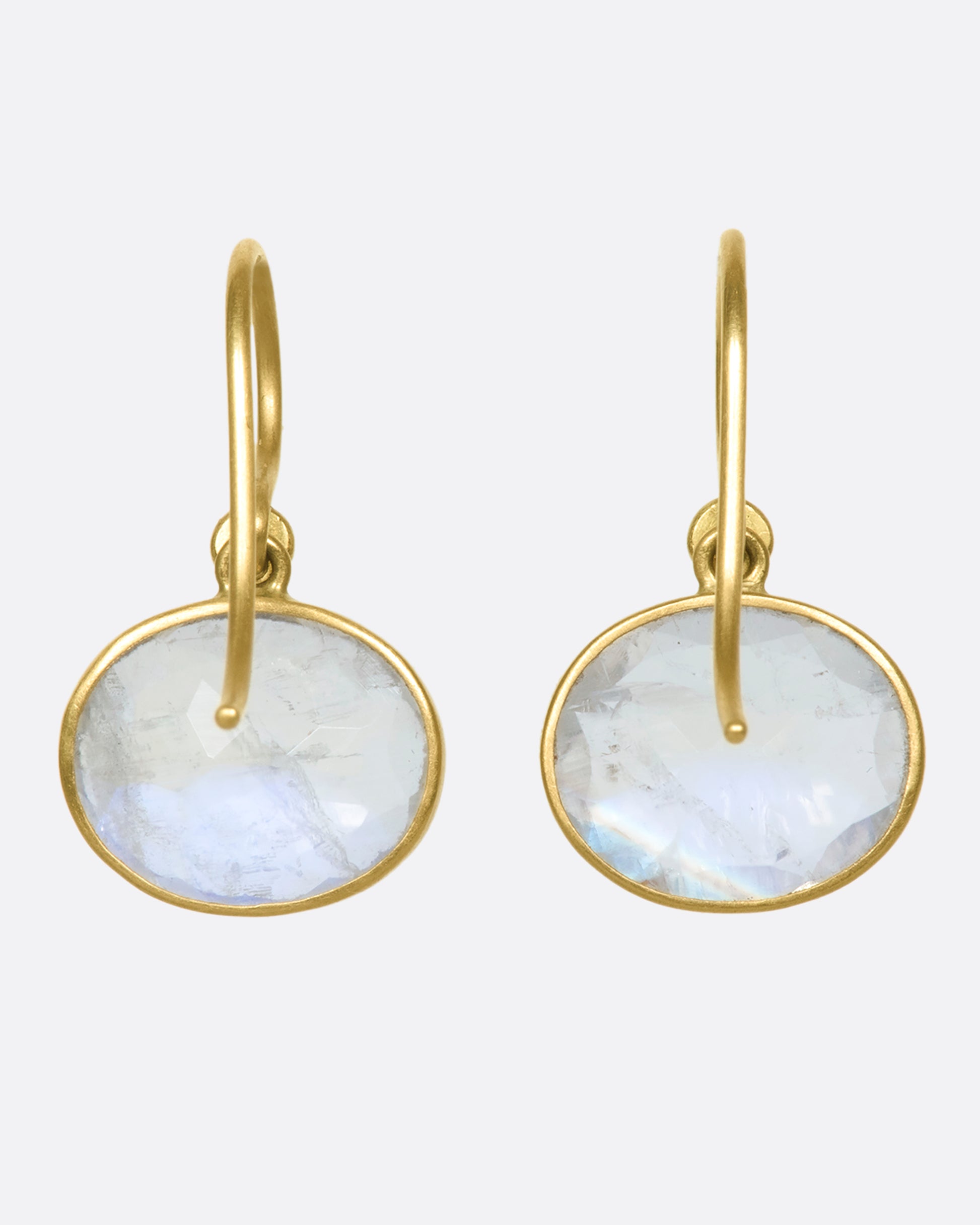 A view of the back of a pair of oval moonstone earrings set in yellow gold bezels.