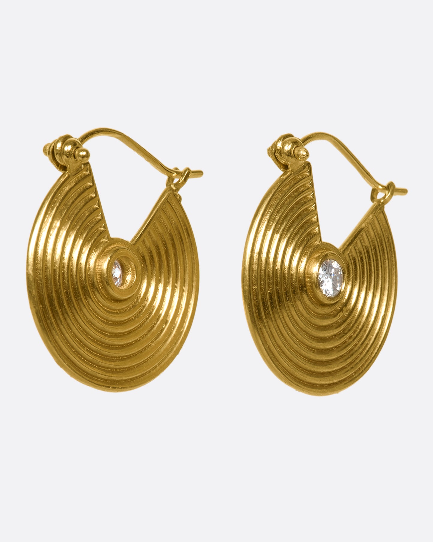 14k gold spiral hoops punctuated with white diamonds. Depending on the angle of your piercing, these may look like thin hoops or gold, ribbed discs from the front.