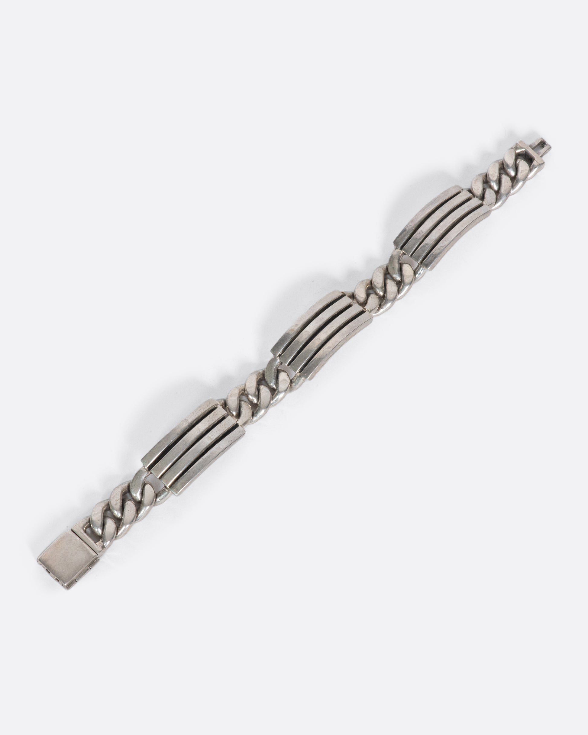A vintage Mexican sterling silver bracelet with alternating ribbed segments and curb chain connections. It's heavy weight and unique design create a substantial presence on your wrist, solo or stacked.