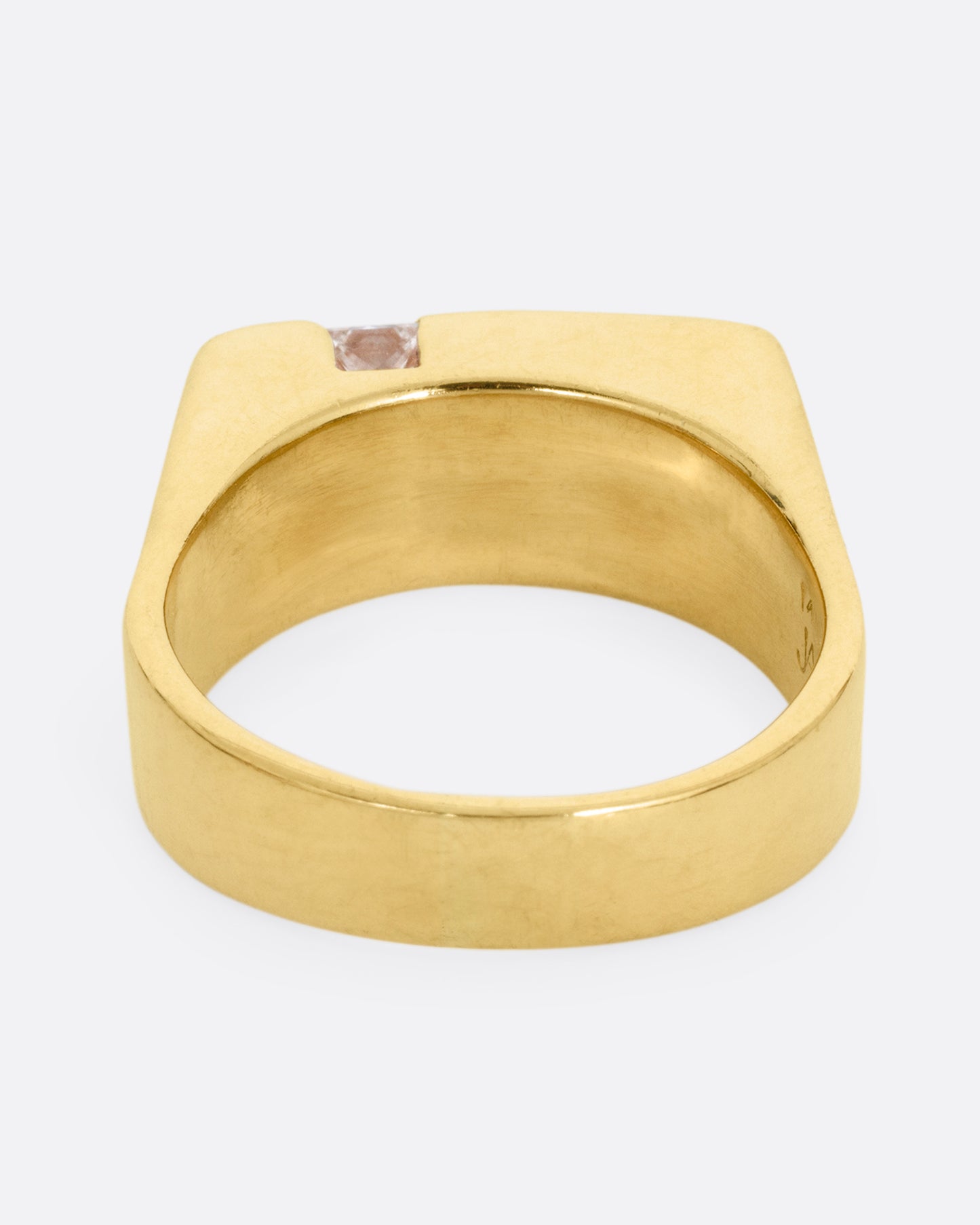 A yellow gold ring with linear channels and two princess cut diamonds, shown from the back. 