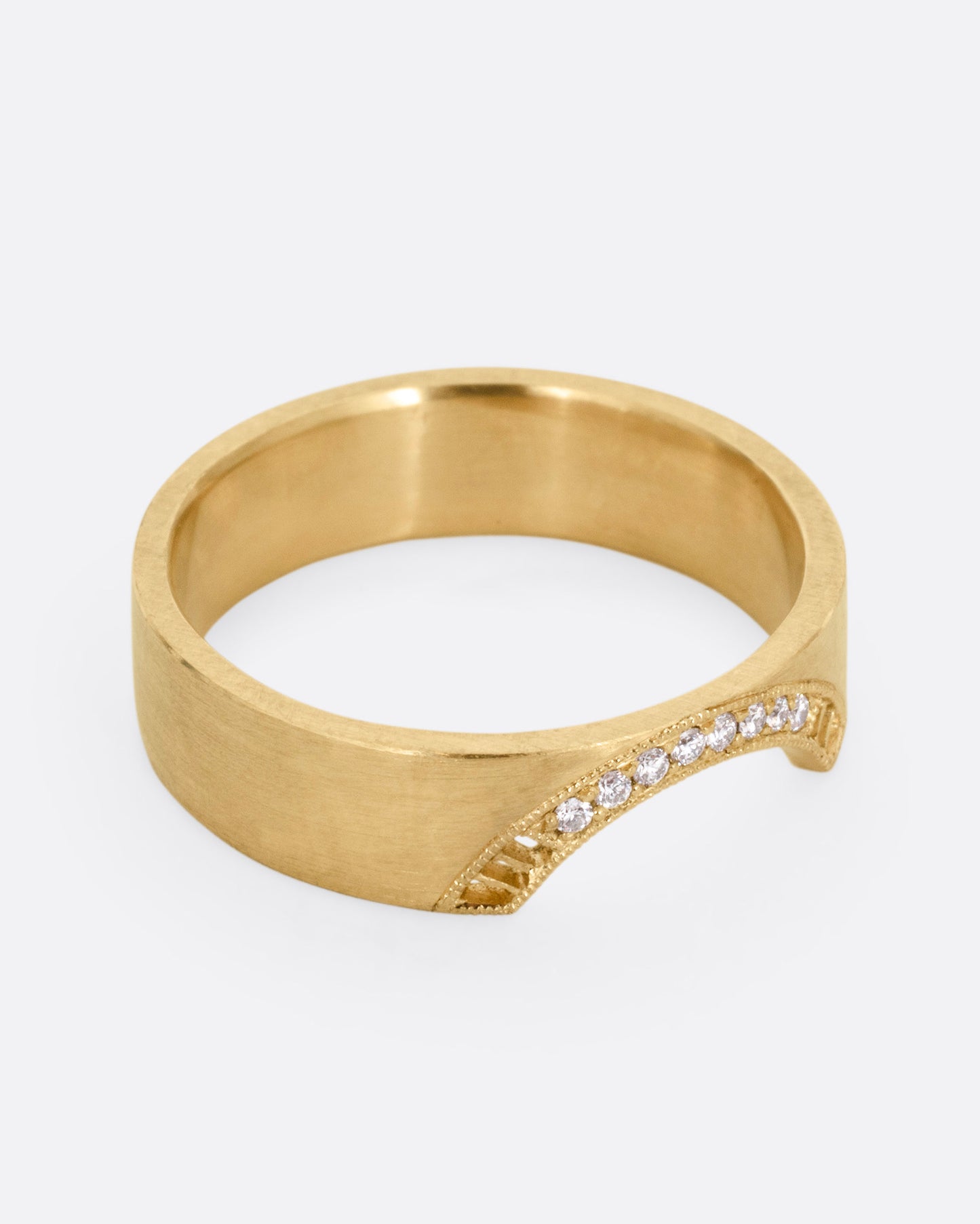 A yellow gold arched ring with eight bead set diamonds set above the half moon cutout at the center, shown from the side.