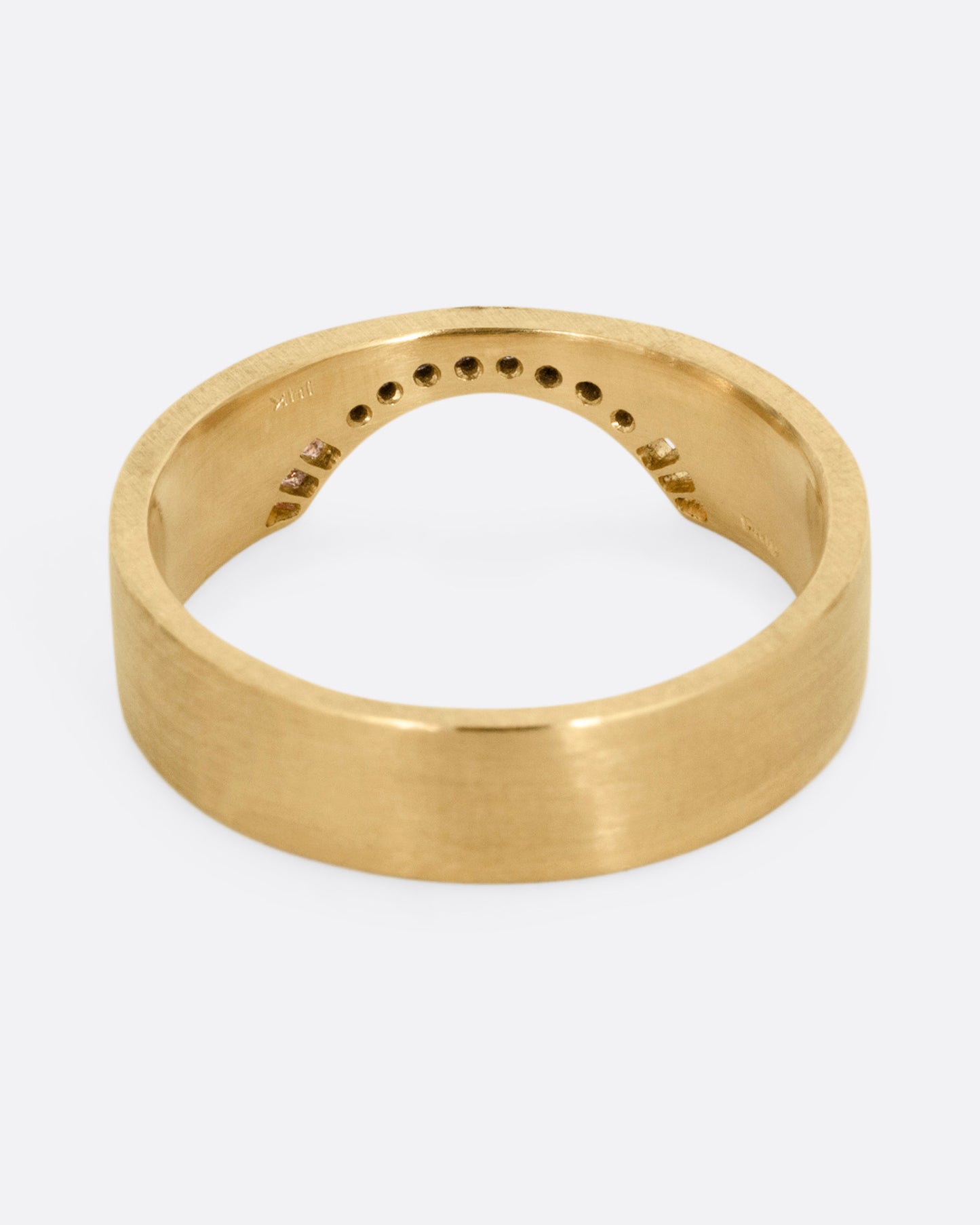 A yellow gold arched ring with eight bead set diamonds set above the half moon cutout at the center, shown from the back.