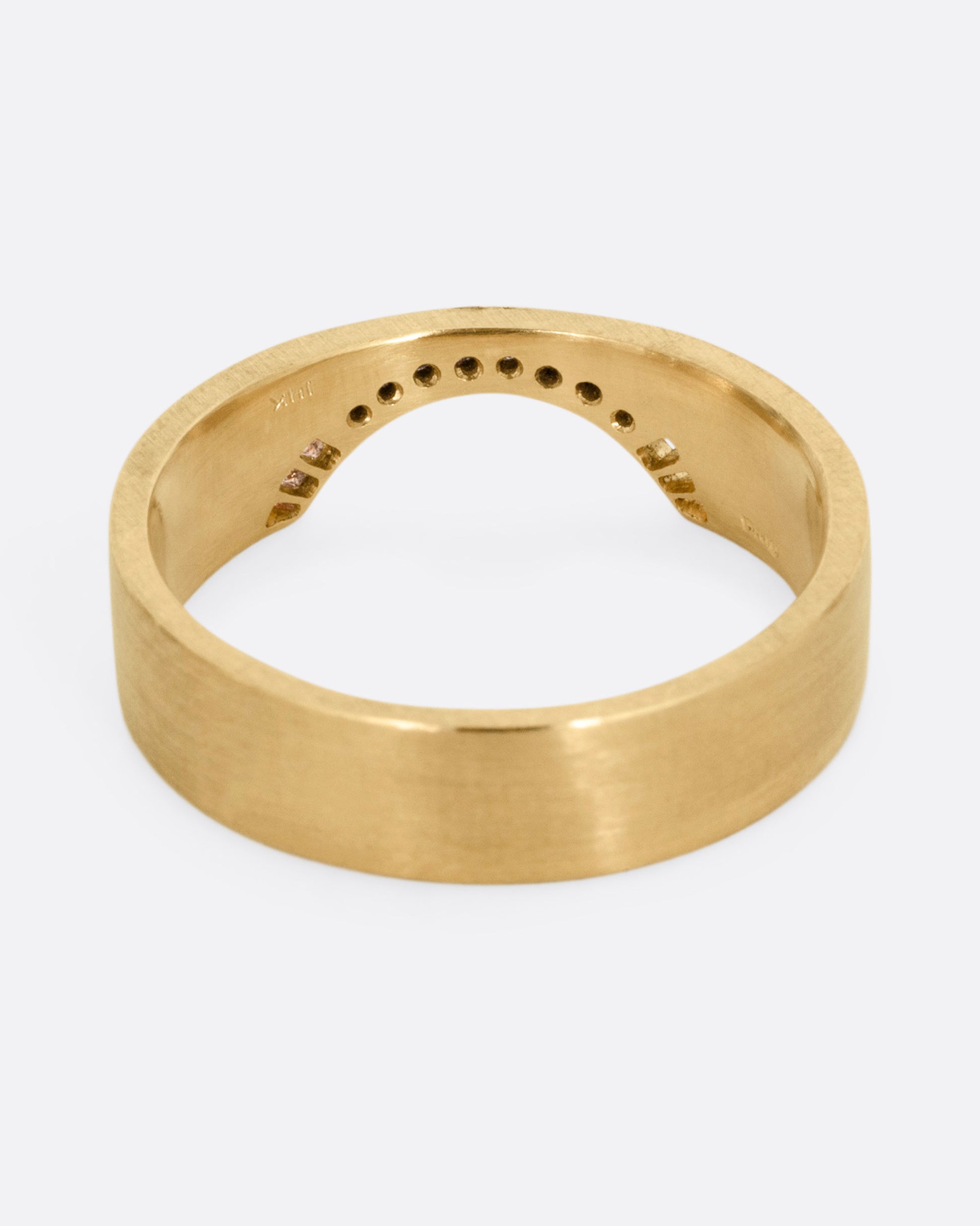 A yellow gold arched ring with eight bead set diamonds set above the half moon cutout at the center, shown from the back.