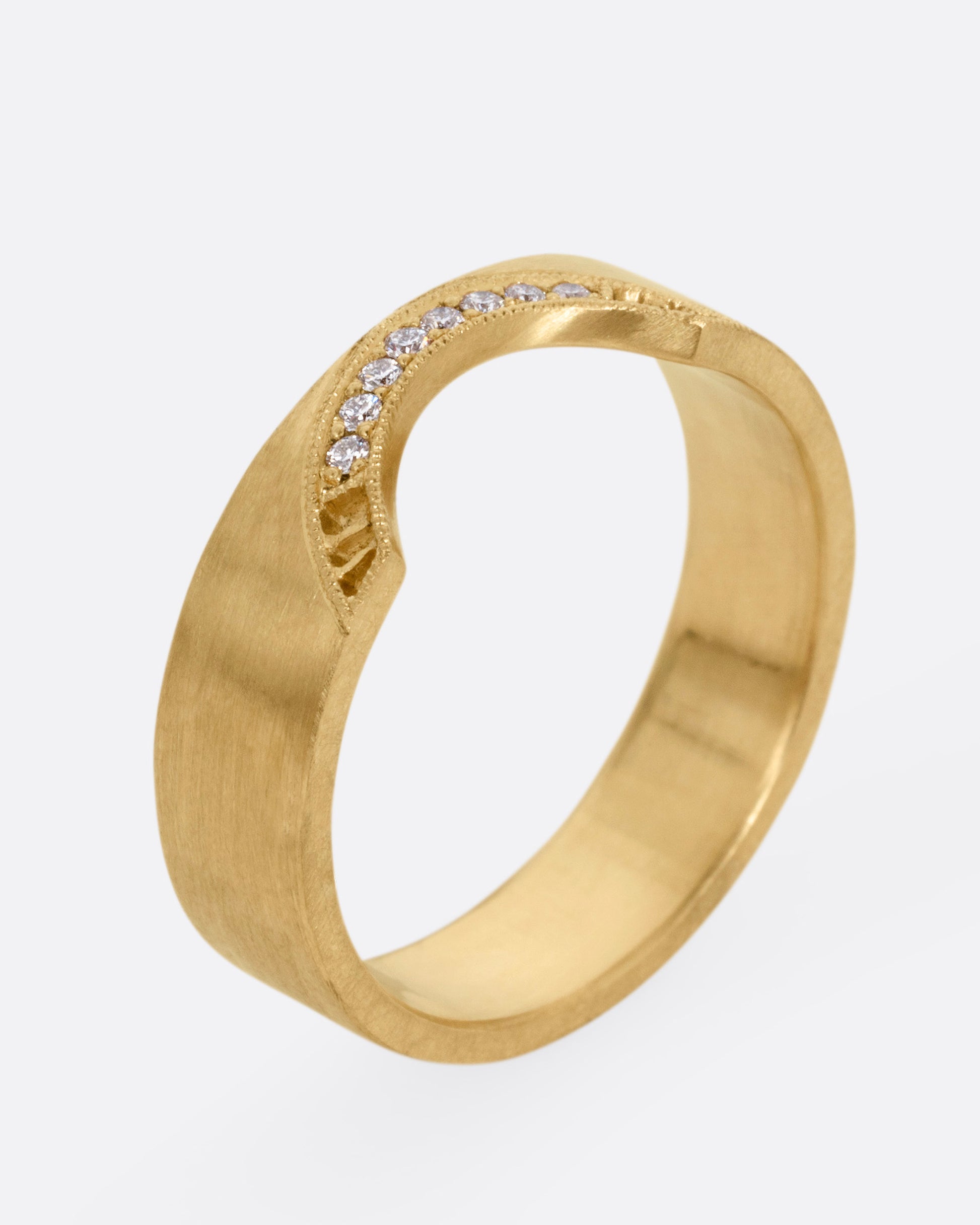 A yellow gold arched ring with eight bead set diamonds set above the half moon cutout at the center, shown from the side standing up.