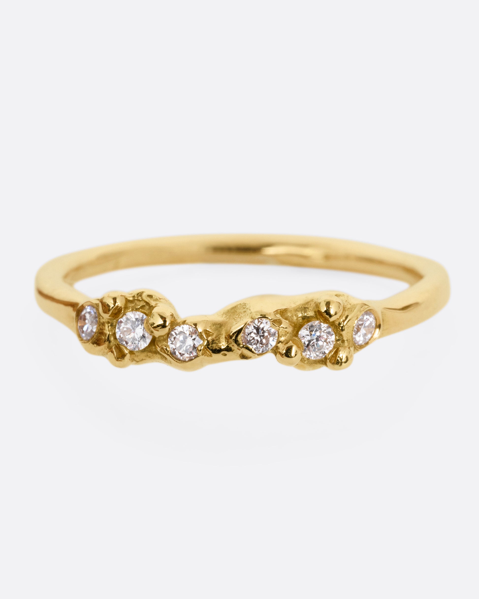A yellow gold ring with a queue of diamonds set into a textural front. Shown from the front.
