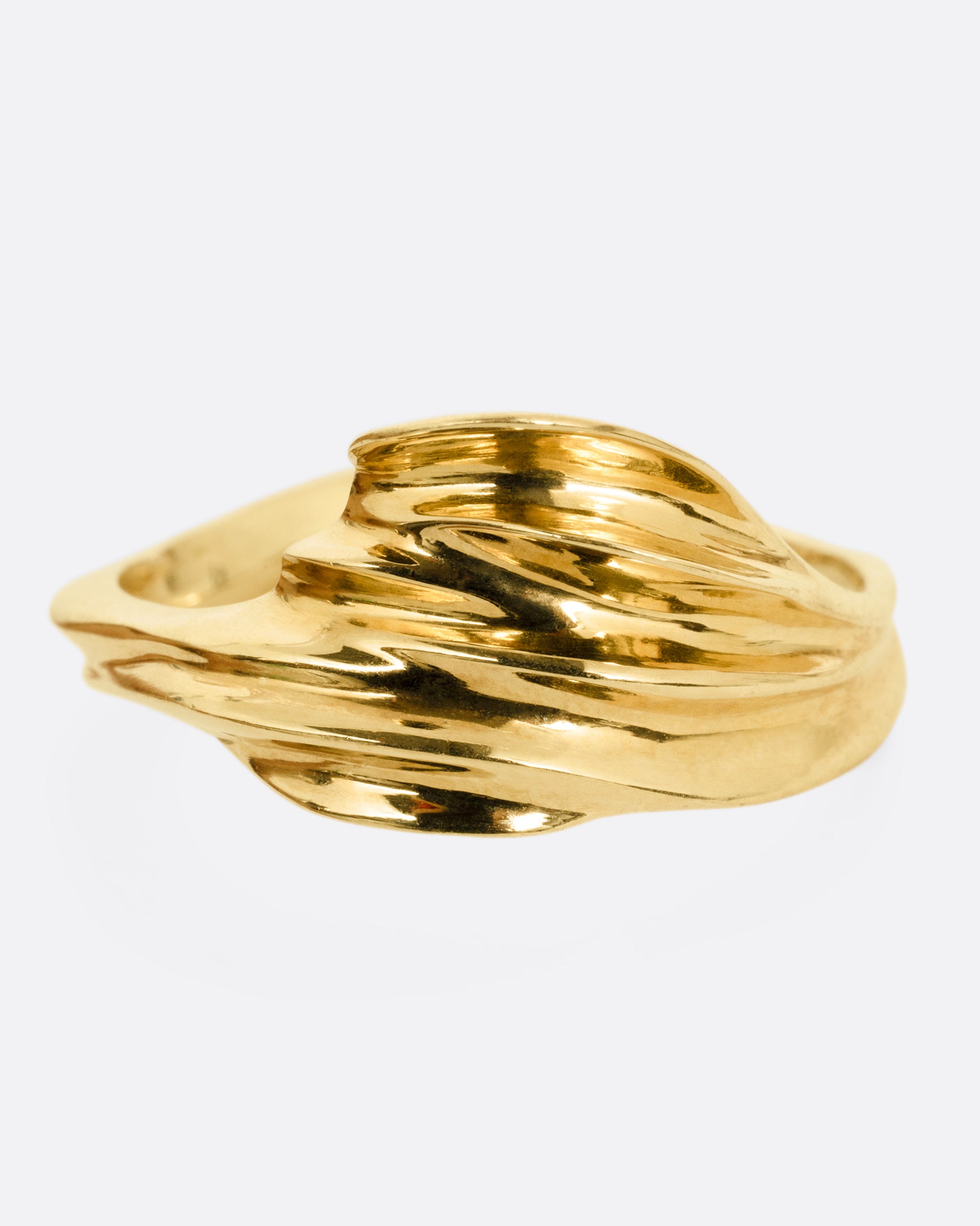 A yellow gold ring with a fluid, dimensional silhouette and narrow back, shown from the front.