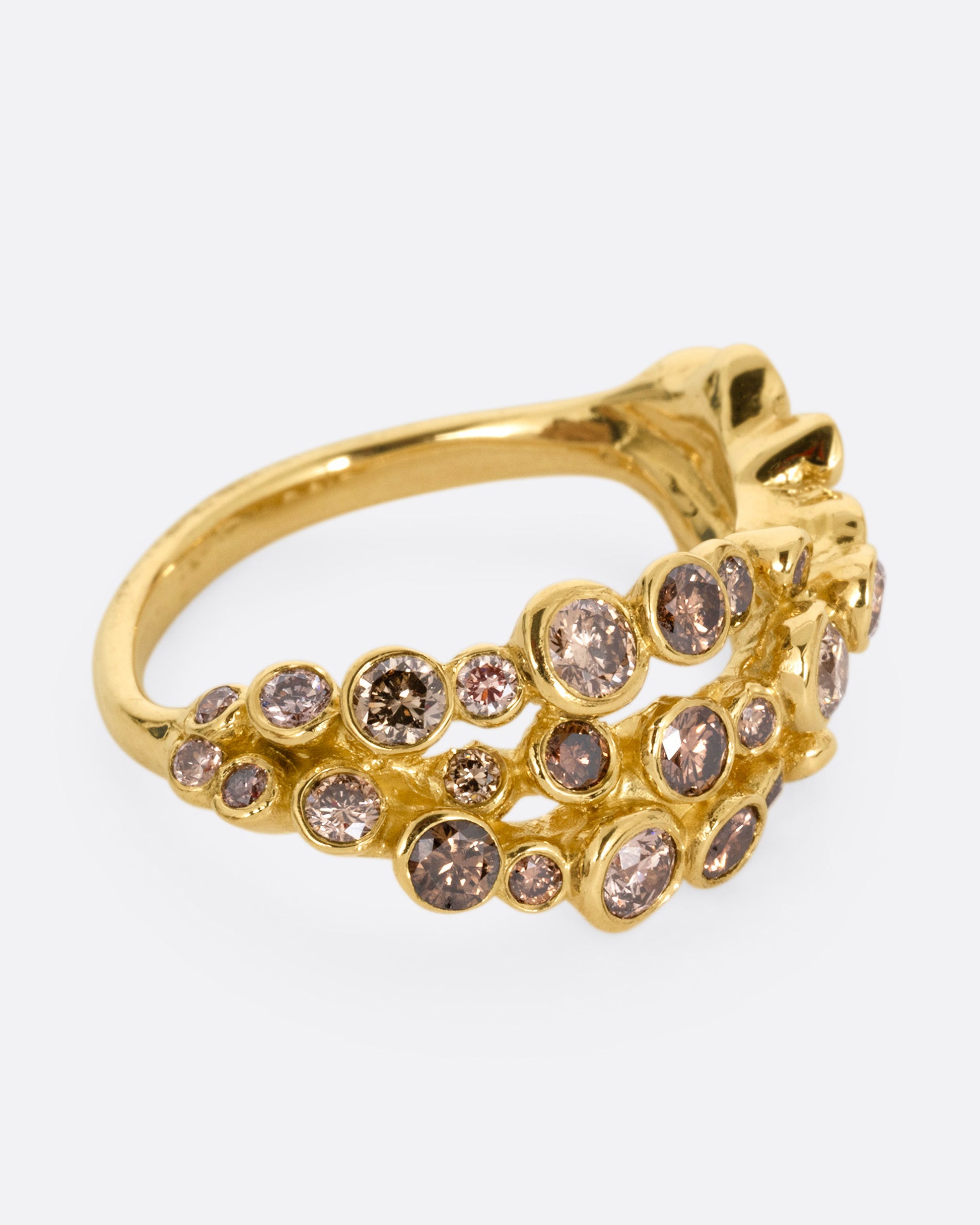 A yellow gold ring with layers of cognac diamonds, shown from the side.