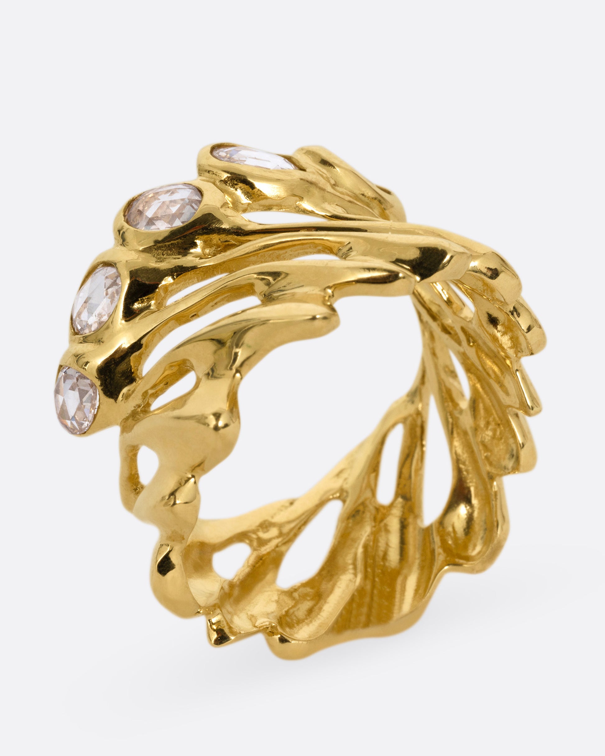 A yellow gold ring with intertwined strands and a queue of rose cut diamonds on its edge, shown standing up from the side.
