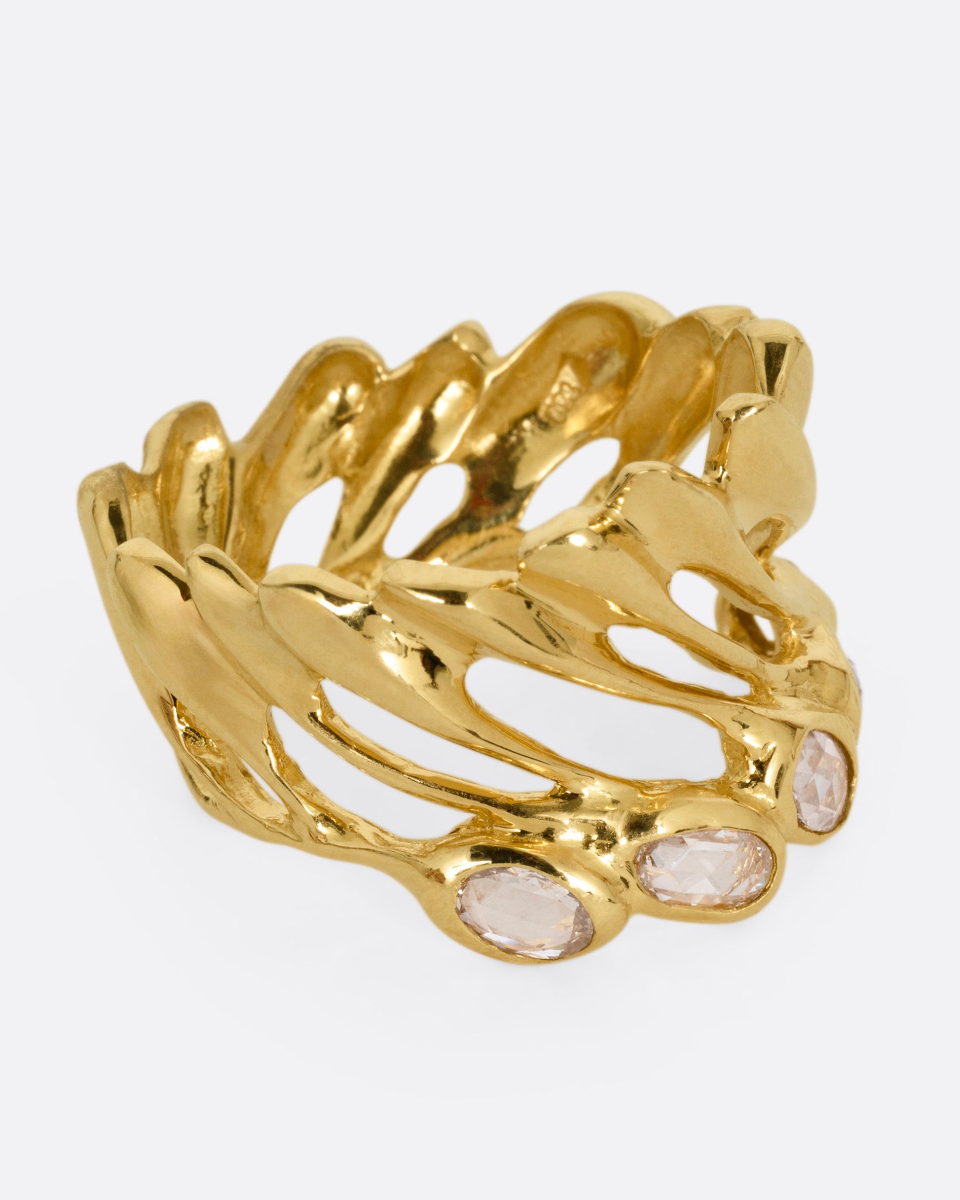 A yellow gold ring with intertwined strands and a queue of rose cut diamonds on its edge, shown from the side.