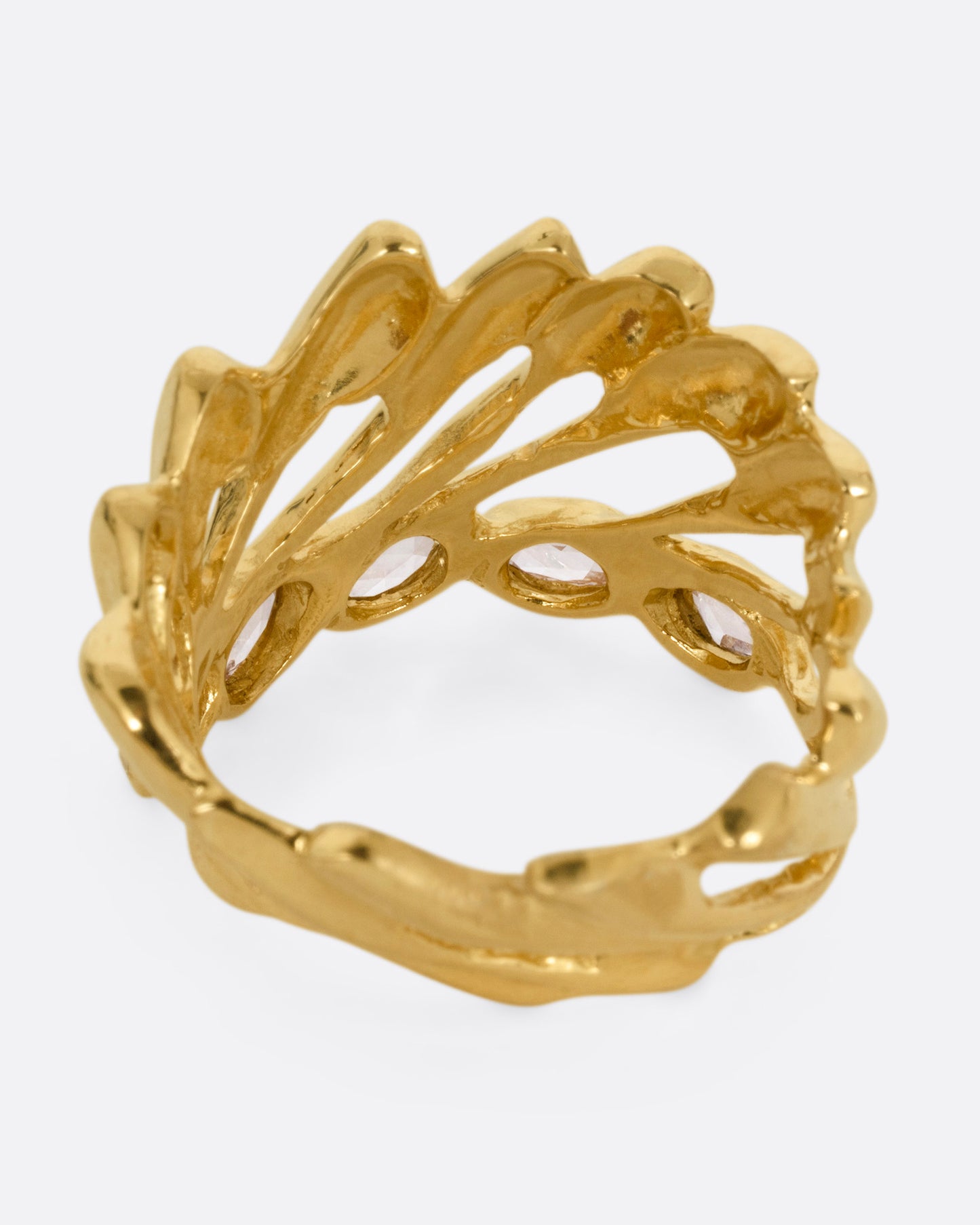A yellow gold ring with intertwined strands and a queue of rose cut diamonds on its edge, shown from the back.