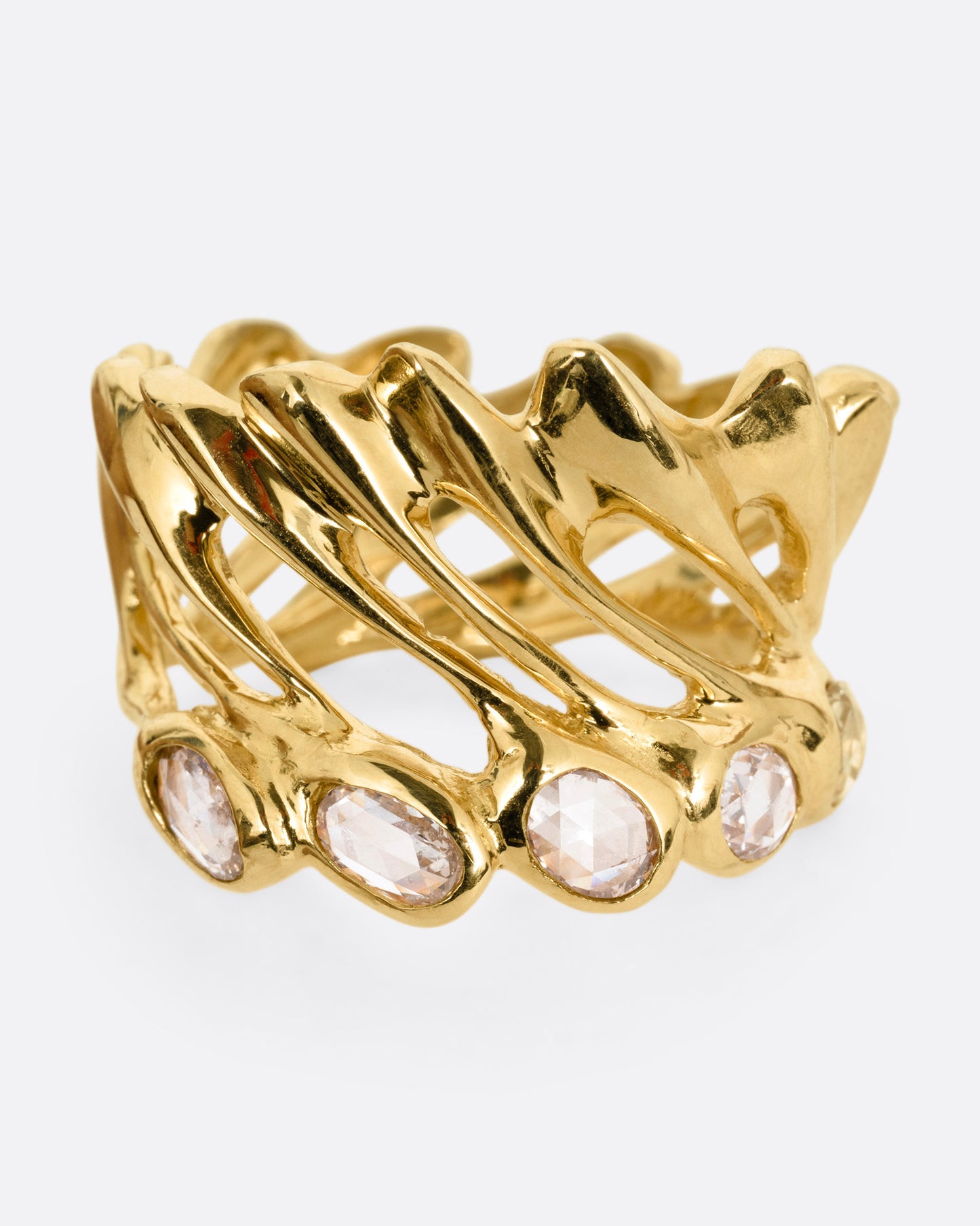 A yellow gold ring with intertwined strands and a queue of rose cut diamonds on its edge, shown from the front.