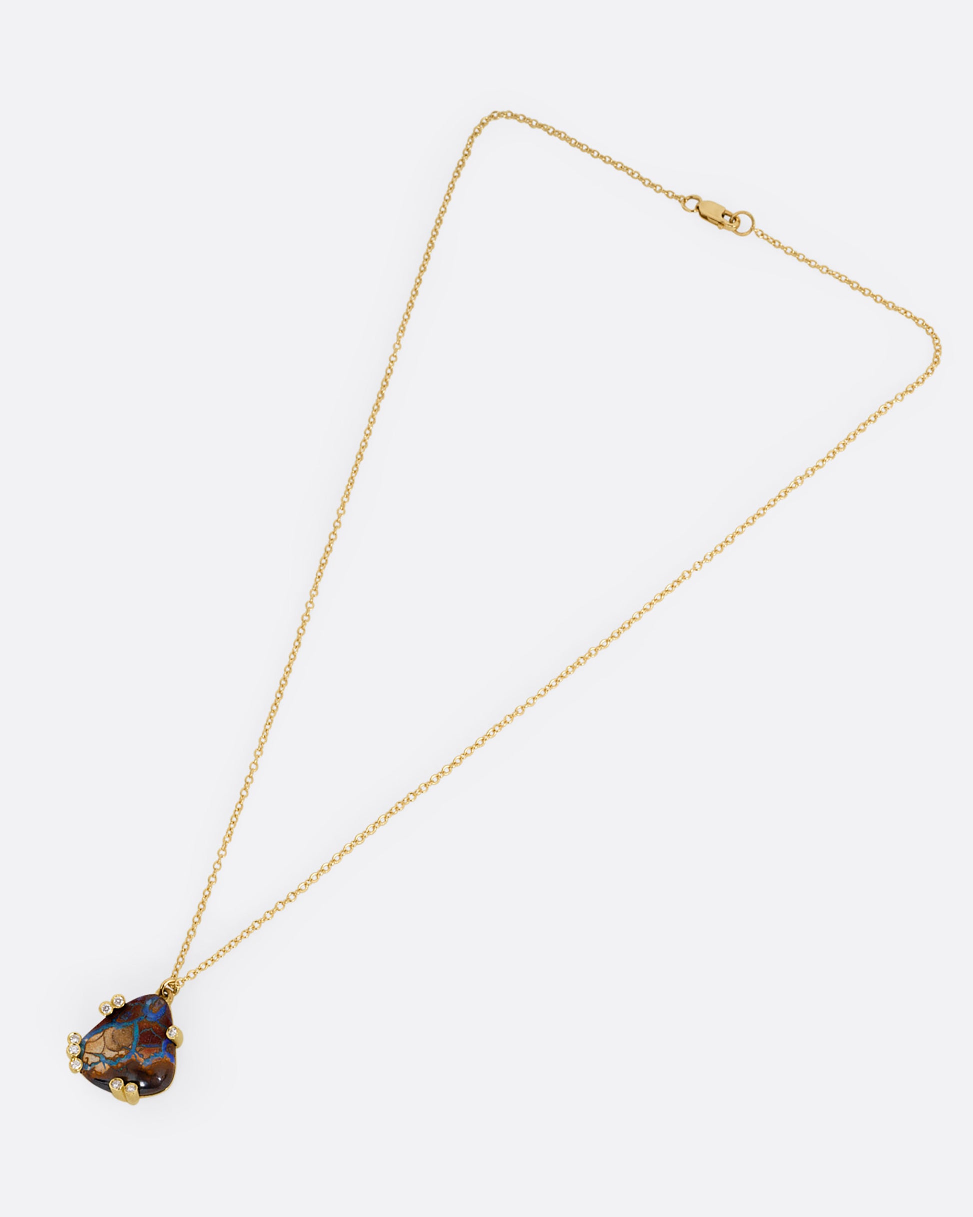 A yellow gold cable chain necklace with a free-form boulder opal and diamond anemones. Shown from the front.