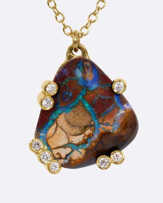 A yellow gold cable chain necklace with a free-form boulder opal and diamond anemones. Shown from the front.