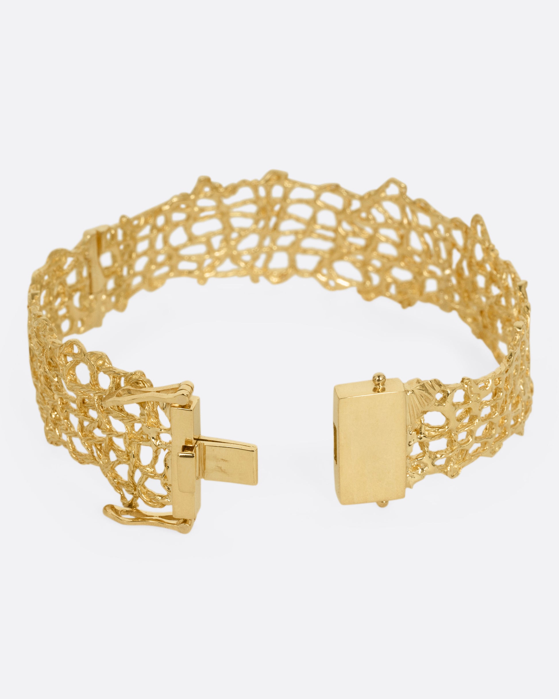 A woven yellow gold wire strand bracelet shown from the back open.