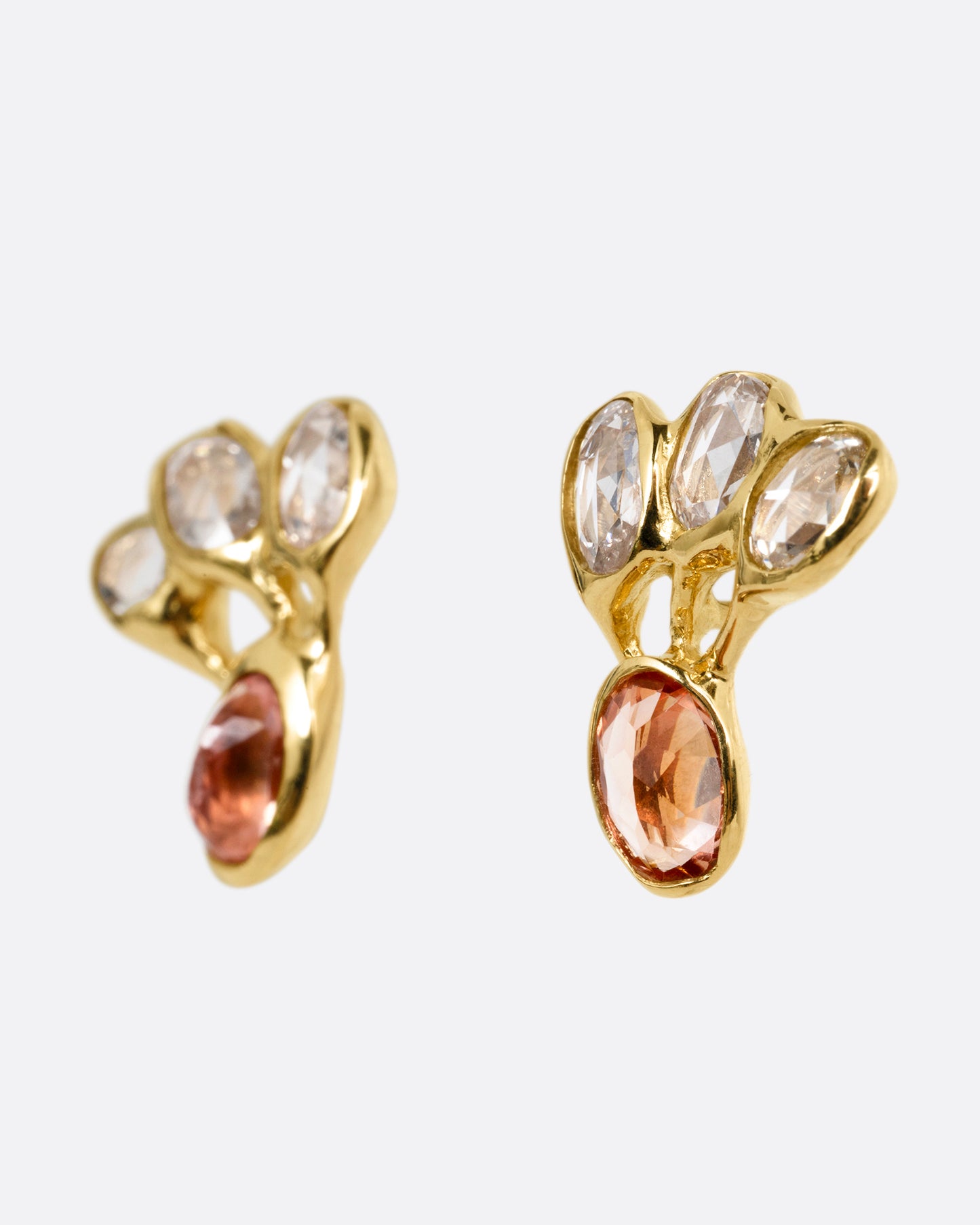 A pair of yellow gold stud earrings with freeform rose cut diamonds and pink tourmalines, shown from the side.