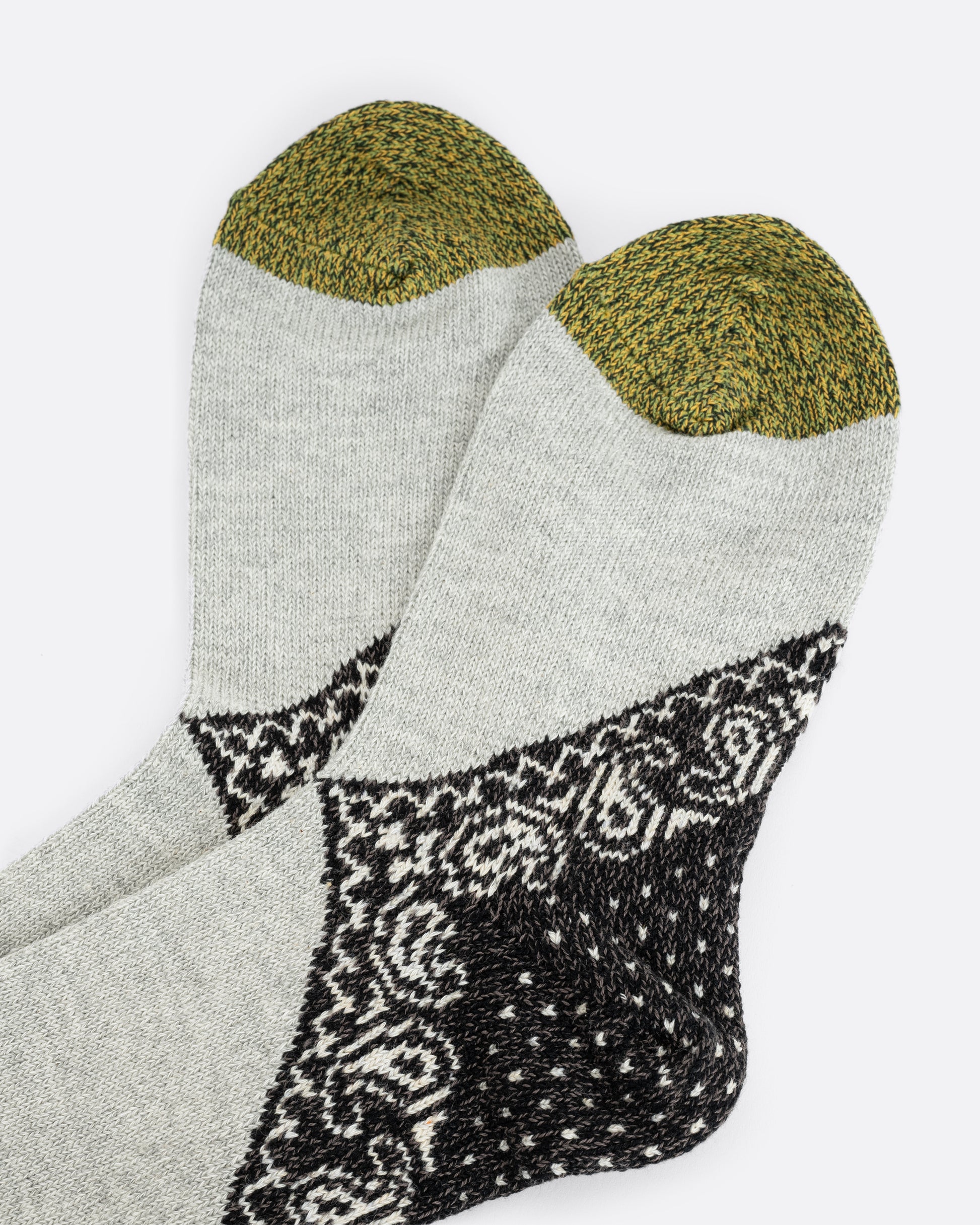 A pair of grey knit socks with black paisley heels. View laying flat.